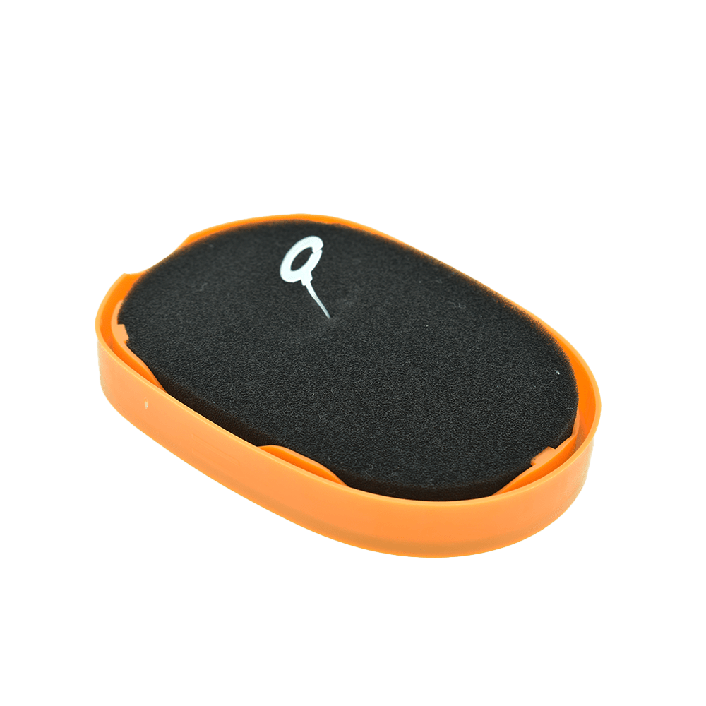 Ein schwarzer Schwamm mit einem weißen Symbol in einer orangen runden Schale auf schwarzem Hintergrund.