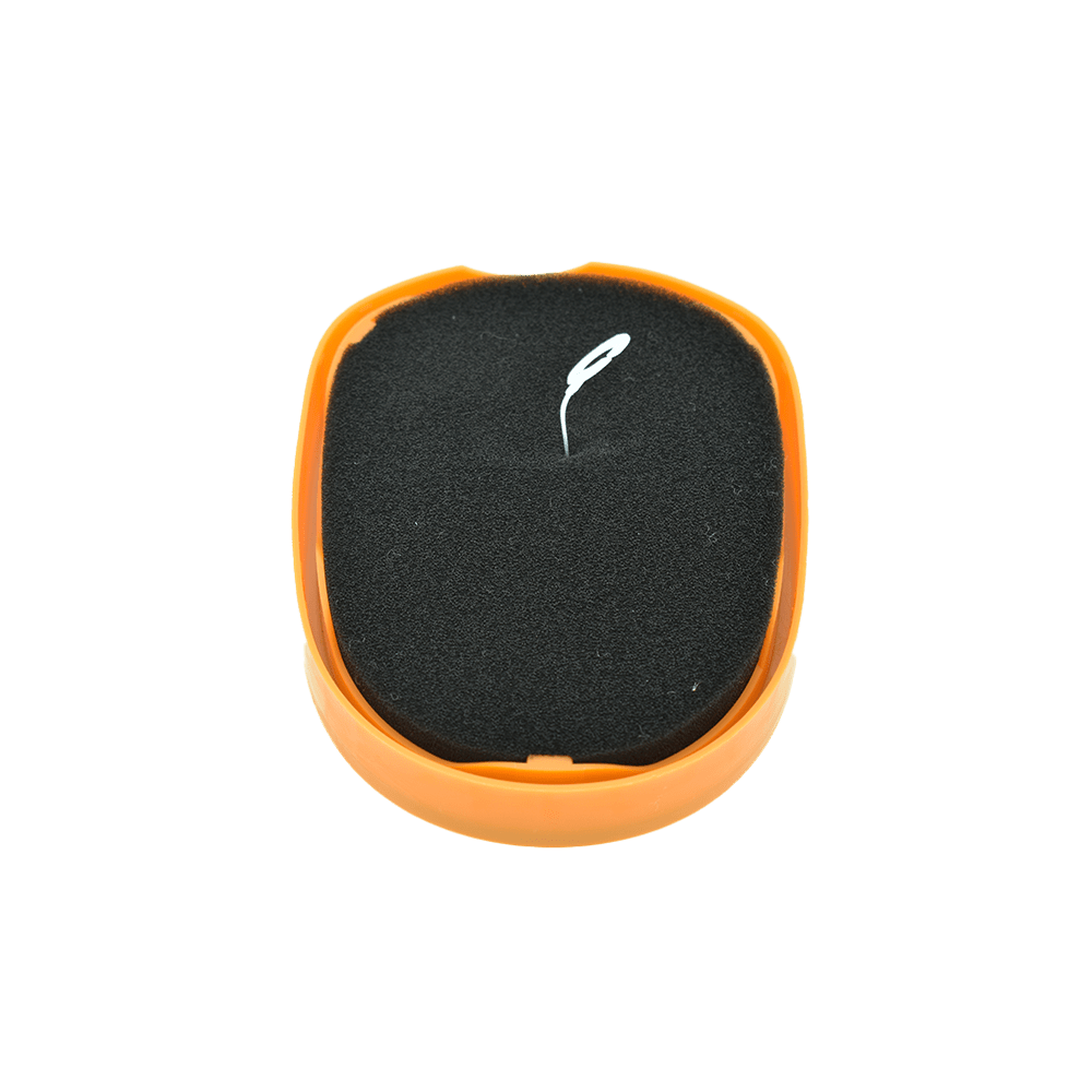 Eine runde orange Schachtel mit schwarzem Schaumstoff und einem kleinen weißen Werkzeug darin vor schwarzem Hintergrund.