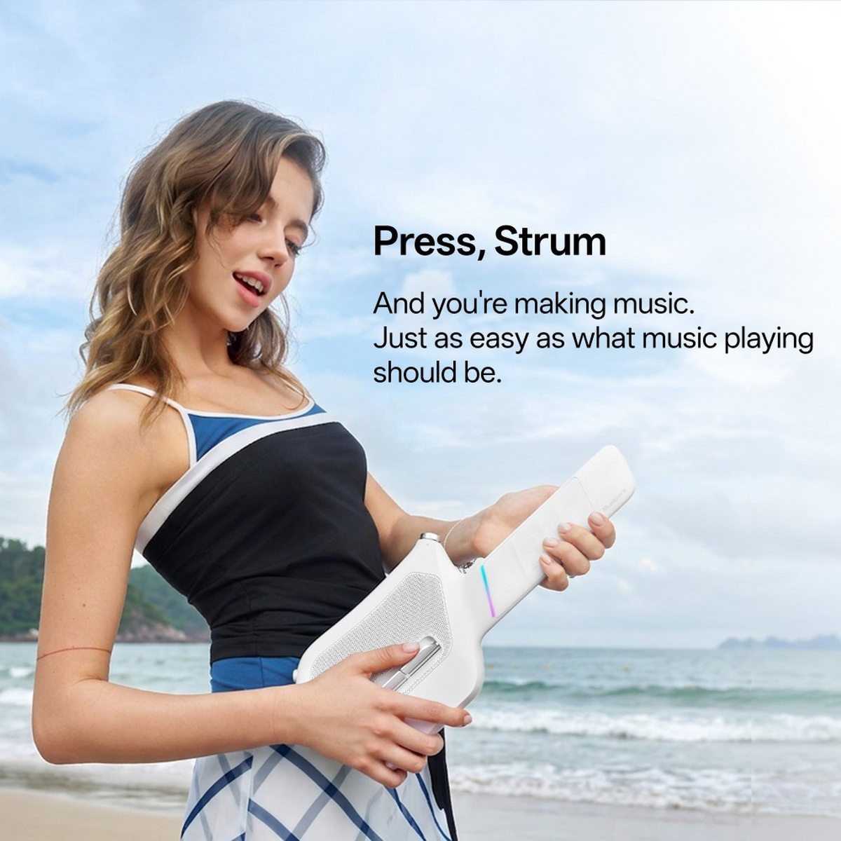 Eine Frau hält ein weißes, elektronisches gitarrenähnliches Musikgerät an einem Strand, mit Text im Himmel.