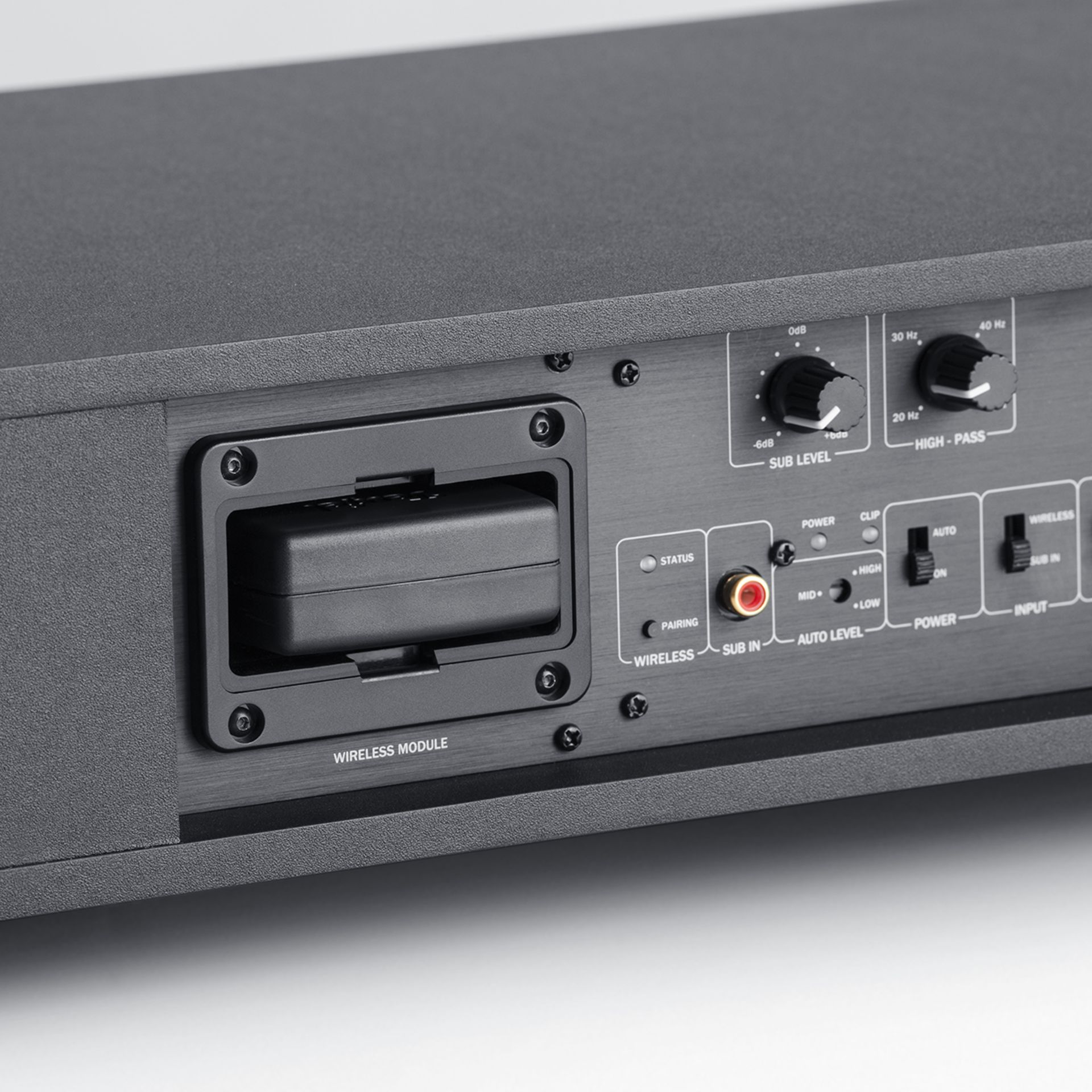 Panneau arrière d'un subwoofer noir doté d'un module sans fil, de boutons de commande et de ports.