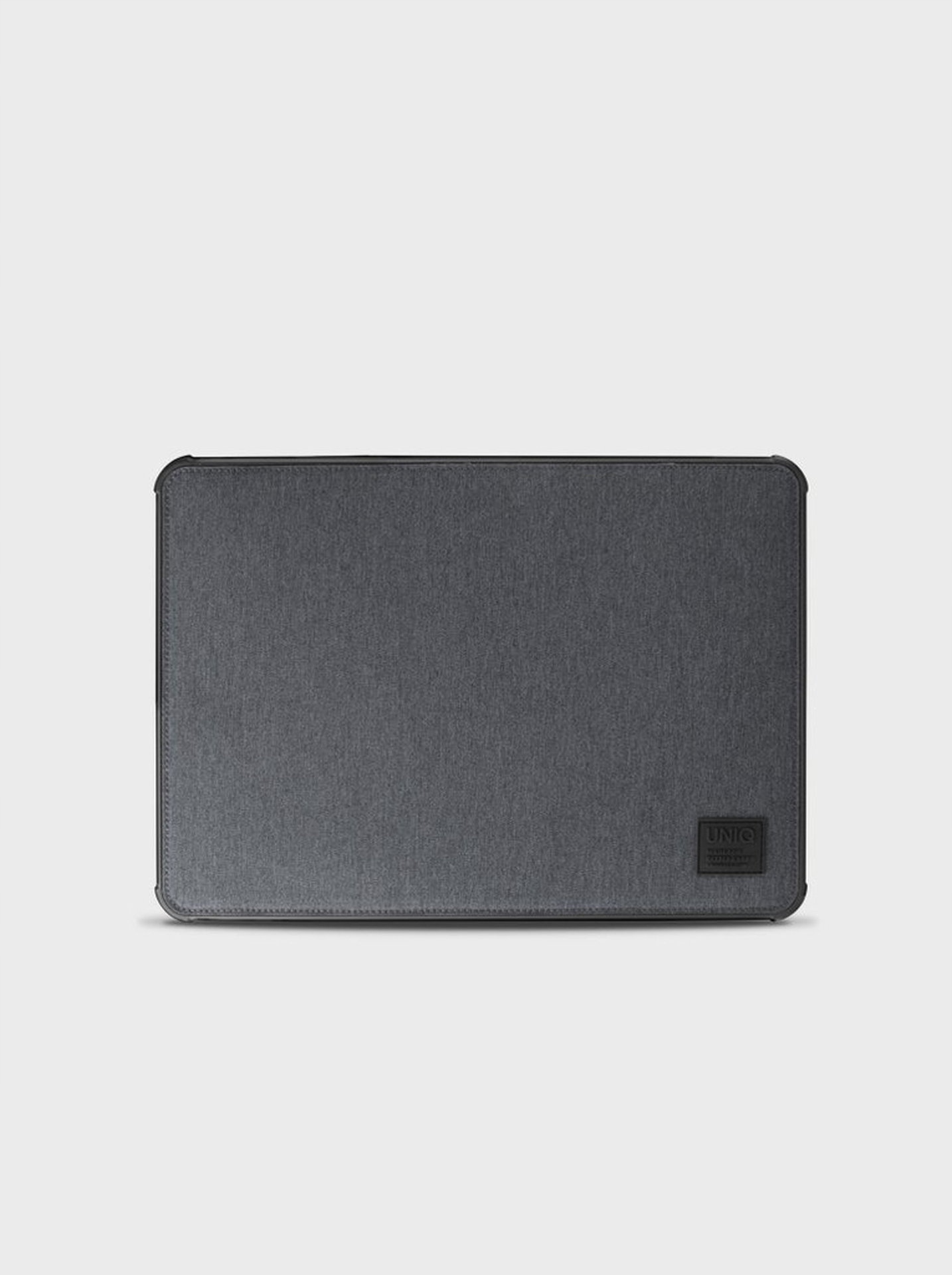 Szary pokrowiec na laptopa z czarnym logo marki w prawym dolnym rogu na jasnym tle.