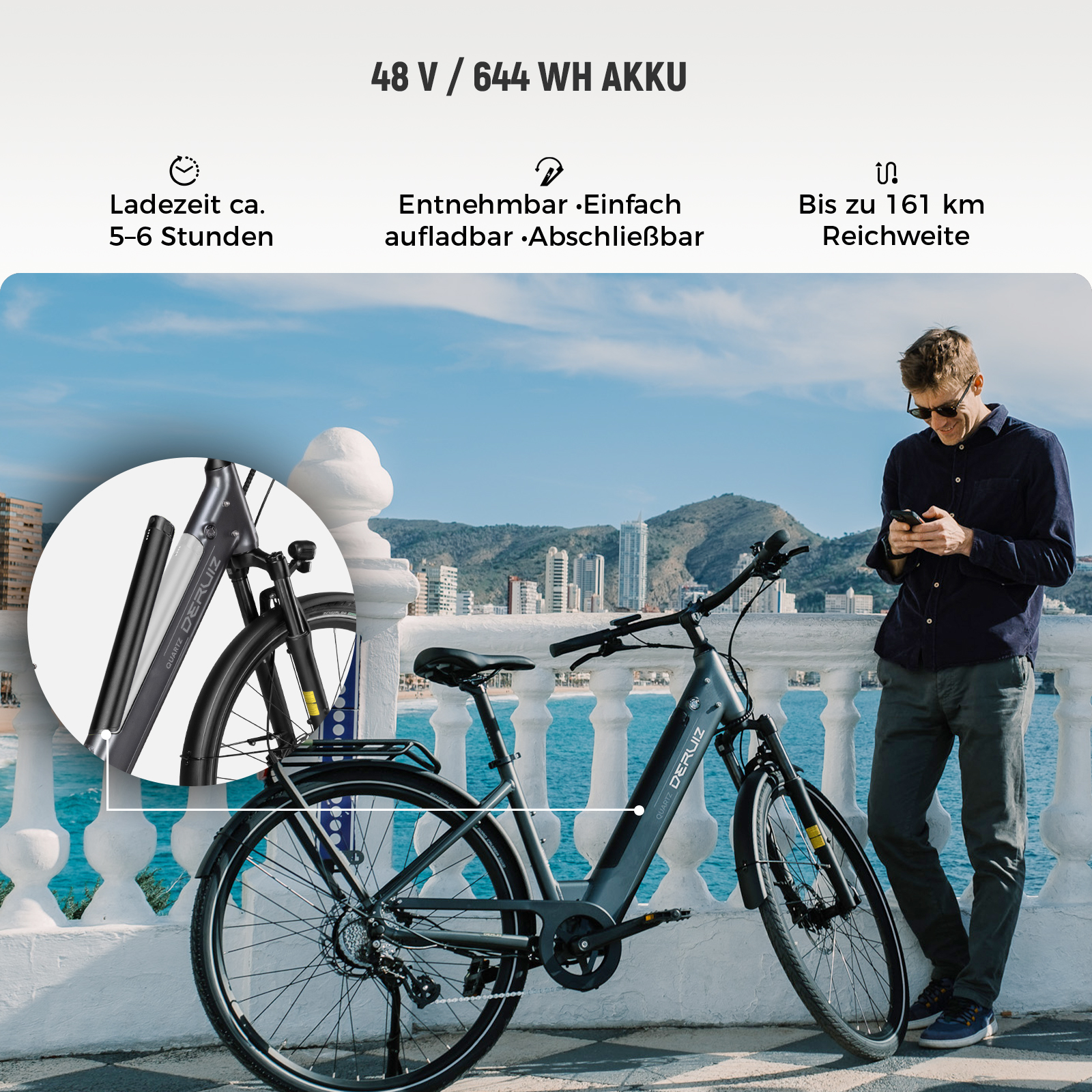 Ein E-Bike mit herausnehmbarem Akku, das an einer Küstenpromenade steht, während ein Mann auf sein Smartphone schaut.