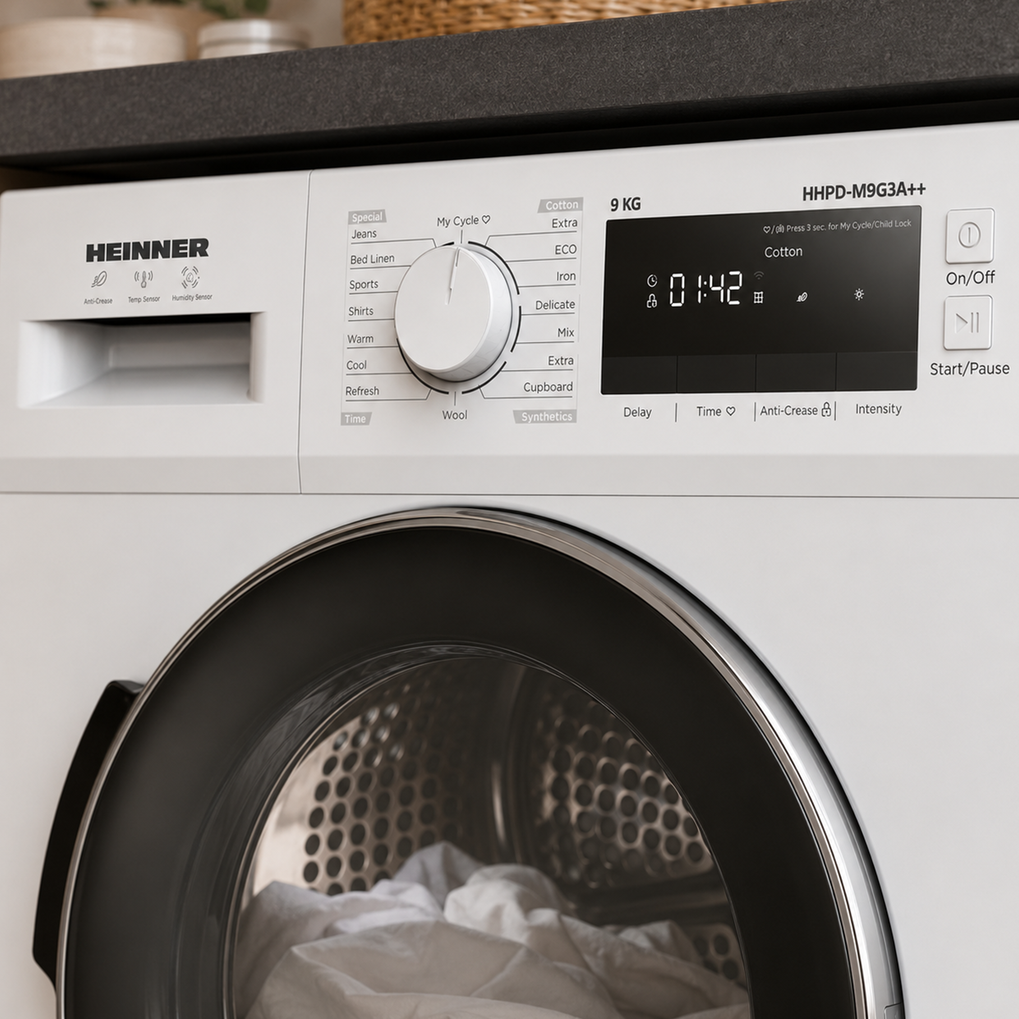 Heinner tumble dryer featuring digital display, program dial, and white drum with laundry inside.