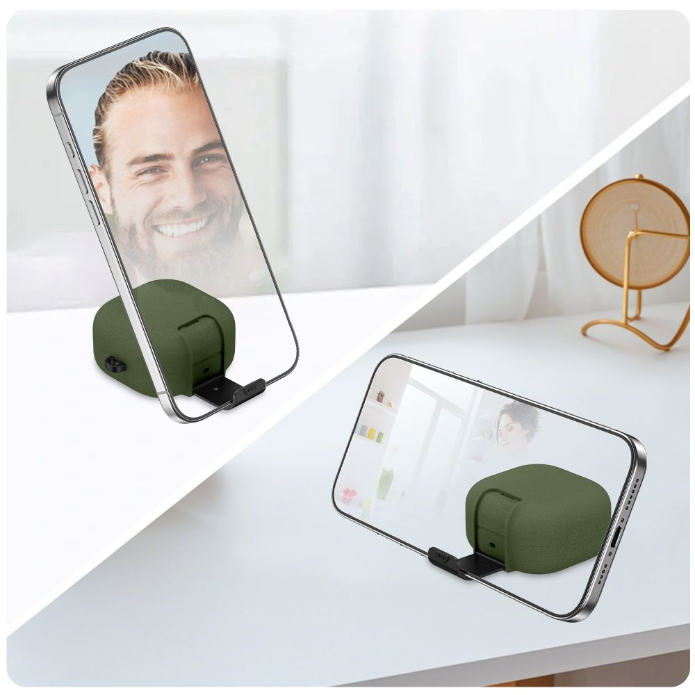 Ein Smartphone steht auf einem kleinen grünen Ständer auf einem weißen Tisch.
