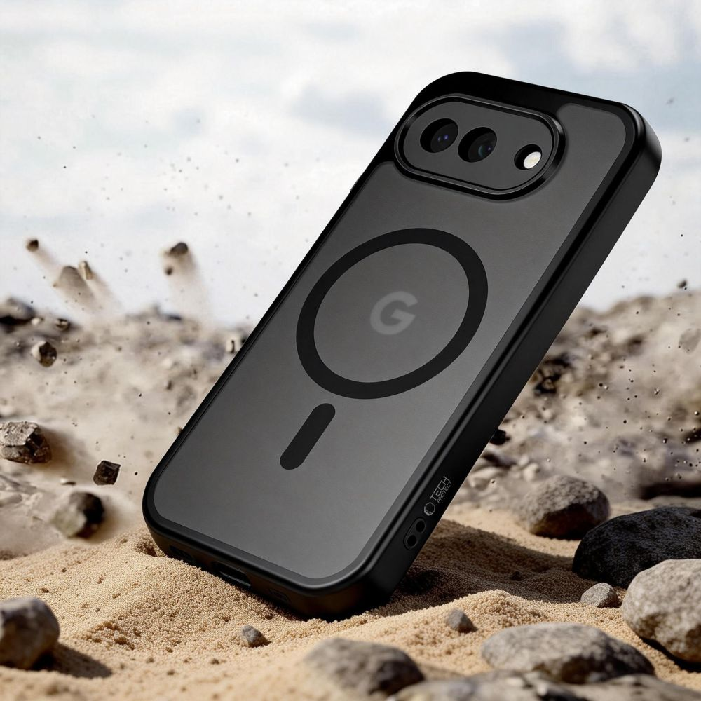 Ein schwarzes Smartphone in einer Schutzhülle steht auf sandigem Boden mit kleinen Steinen und aufgewirbeltem Staub.