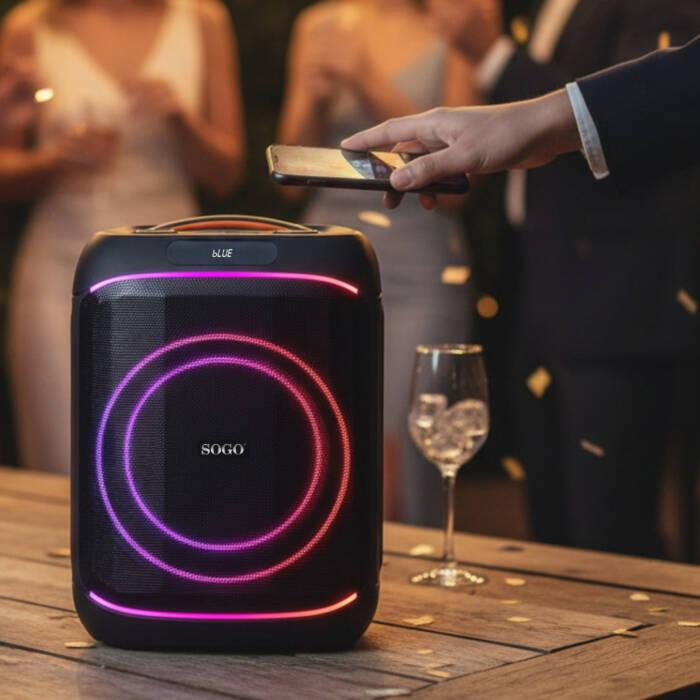 Un altoparlante illuminato su un tavolo collegato a uno smartphone a una festa.