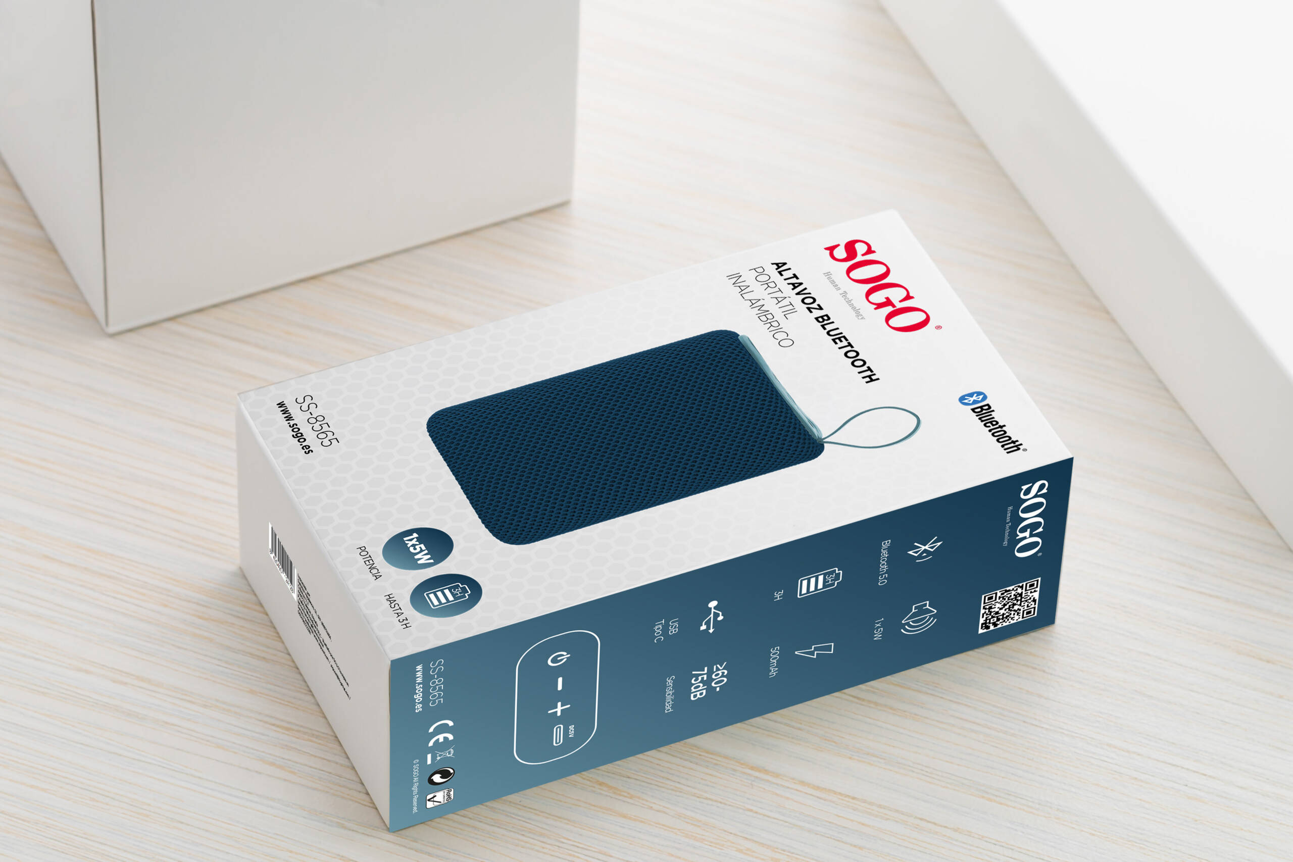 Una scatola di prodotti bianca e blu per un altoparlante Bluetooth portatile SOGO su una superficie in legno.