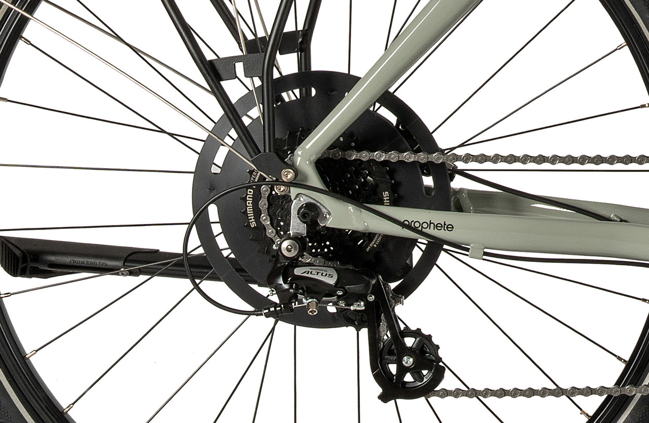 Nahaufnahme des Hinterrads eines grünen Fahrrads mit Shimano Altus Schaltung und Kettenschutz.