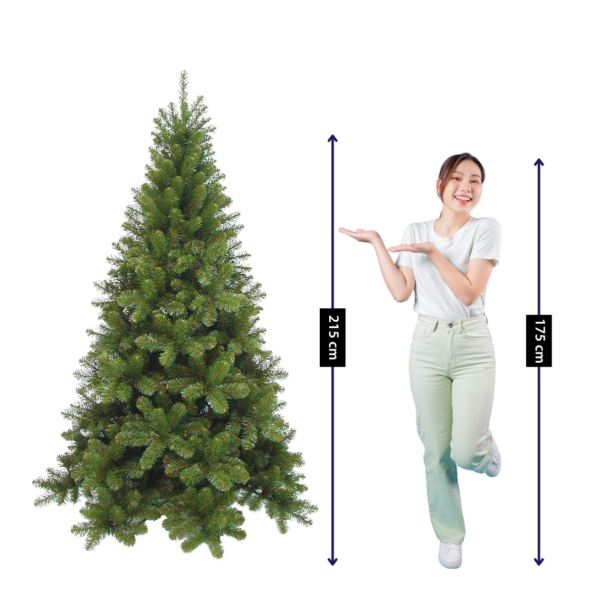 A woman poses next to a 215 cm tall artificial Christmas tree against a white background.