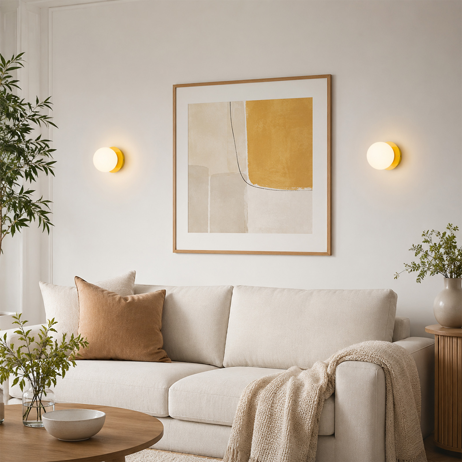 Una sala de estar acogedora con sofá claro, cojín marrón, arte abstracto en la pared y lámparas iluminadas.
