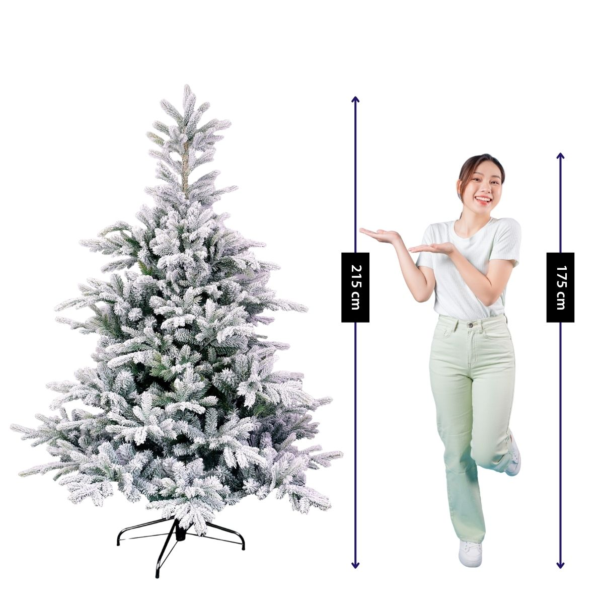 A smiling woman in a white shirt gestures toward a frosted artificial Christmas tree, with height measurement lines.