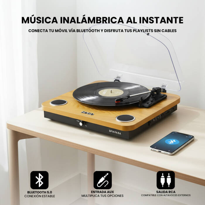 Un giradischi in legno con vinile si trova su una scrivania accanto a uno smartphone.