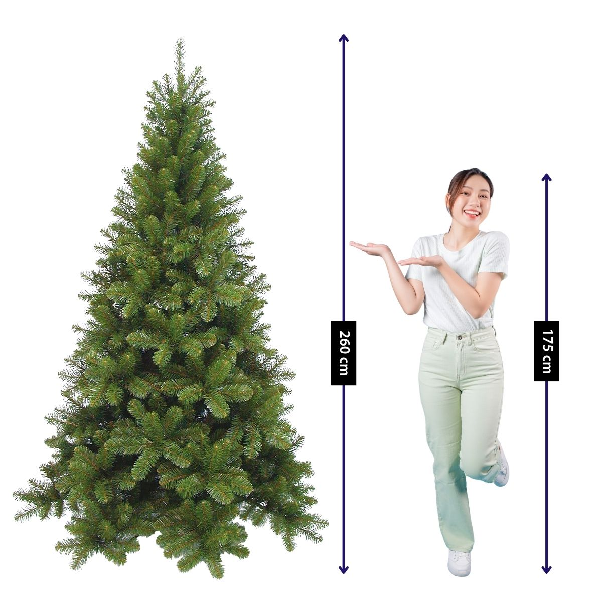 Een vrouw staat naast een 260 cm hoge kunstkerstboom en gebaart ernaar.