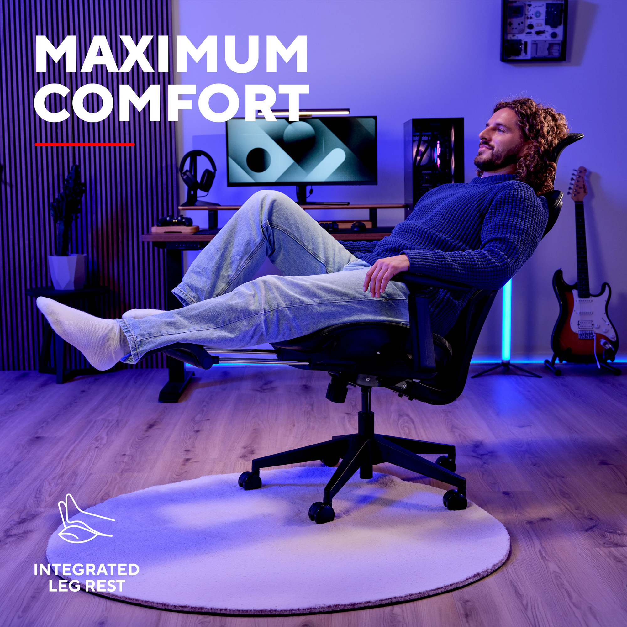 Un uomo siede a gambe incrociate su una sedia ergonomica con poggiapiedi integrato in una stanza illuminata di blu.