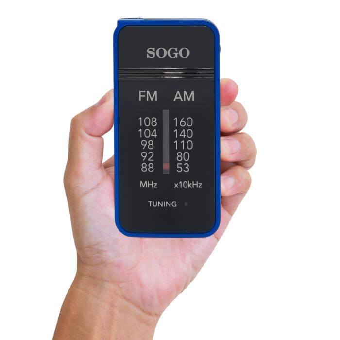 Una mano tiene una radio tascabile Sogo blu compatta con scale di frequenza FM e AM.