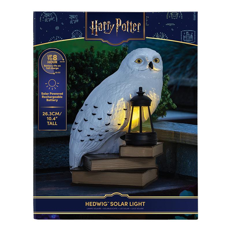Luz solar Hedwig de Harry Potter, búho blanco sobre libros con linterna brillante, imagen de embalaje.