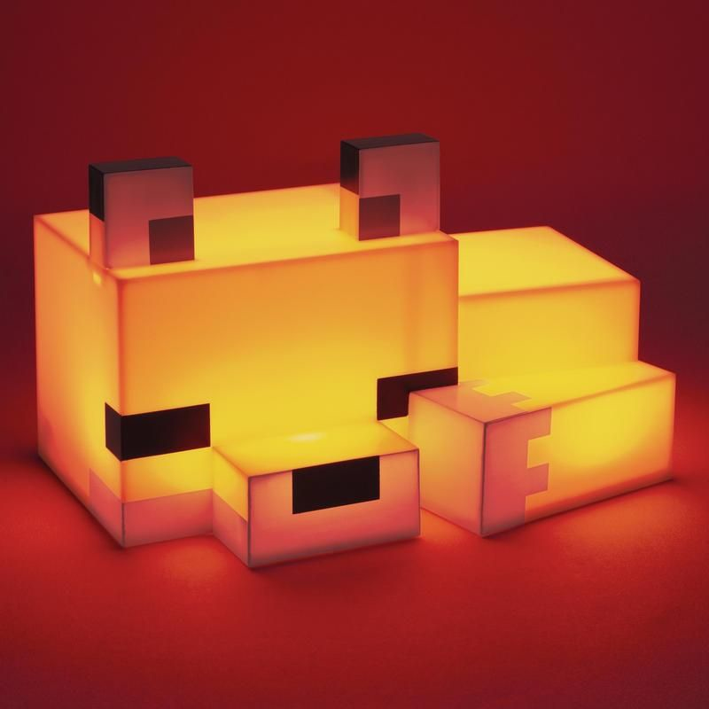 Ein pixeliges Blockfuchs-Nachtlicht leuchtet warm gelb vor rotem Hintergrund.