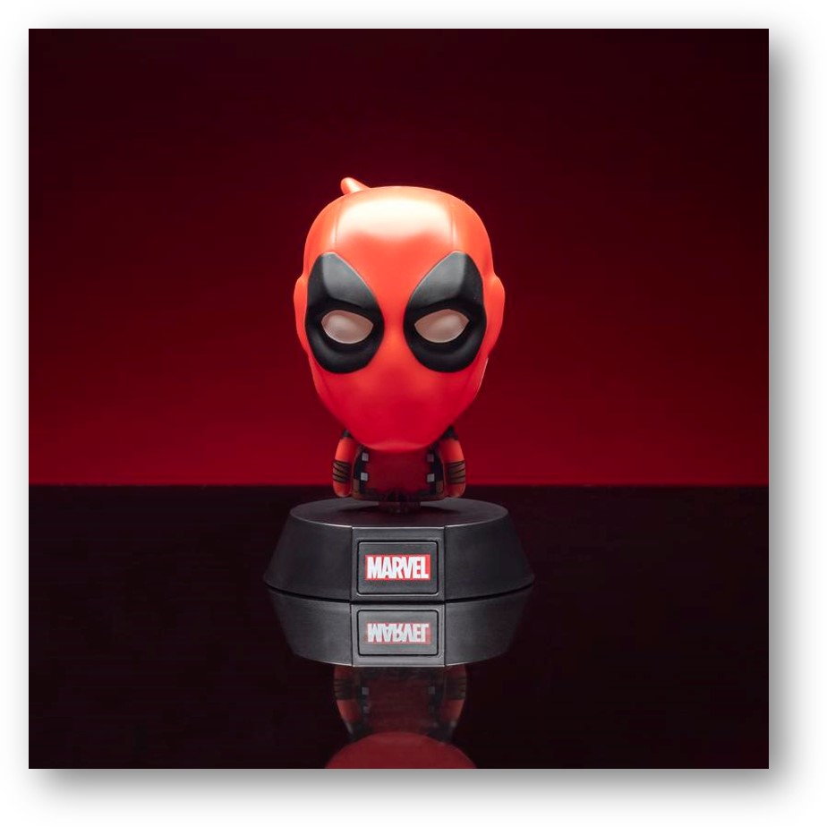 Una figura estilizada de Deadpool con cabeza grande se encuentra en un soporte negro de Marvel sobre fondo rojo oscuro.