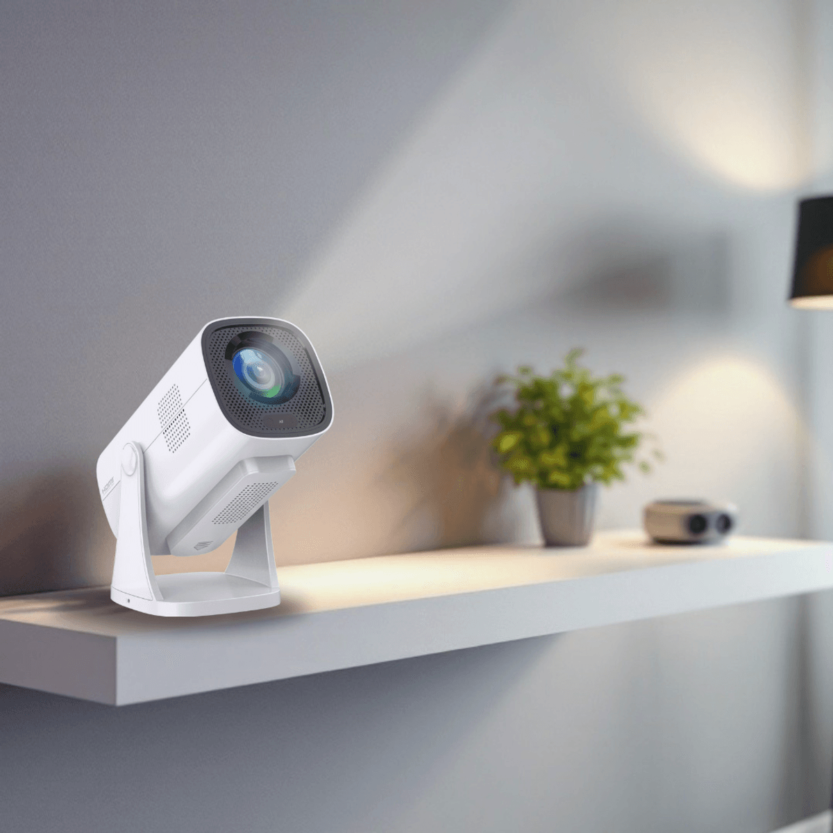 Un proyector blanco con soporte ajustable sobre una balda ante una pared, con una planta en maceta y una lámpara al fondo.