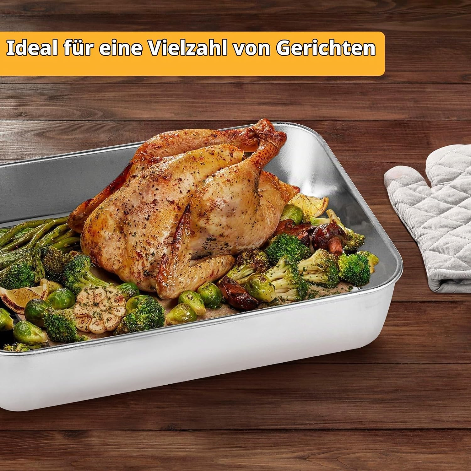 Ein gebratenes HÃ¤hnchen mit BrÃ¼sselsprossen, Brokkoli und Knoblauch in einer Metallschale auf Holz.