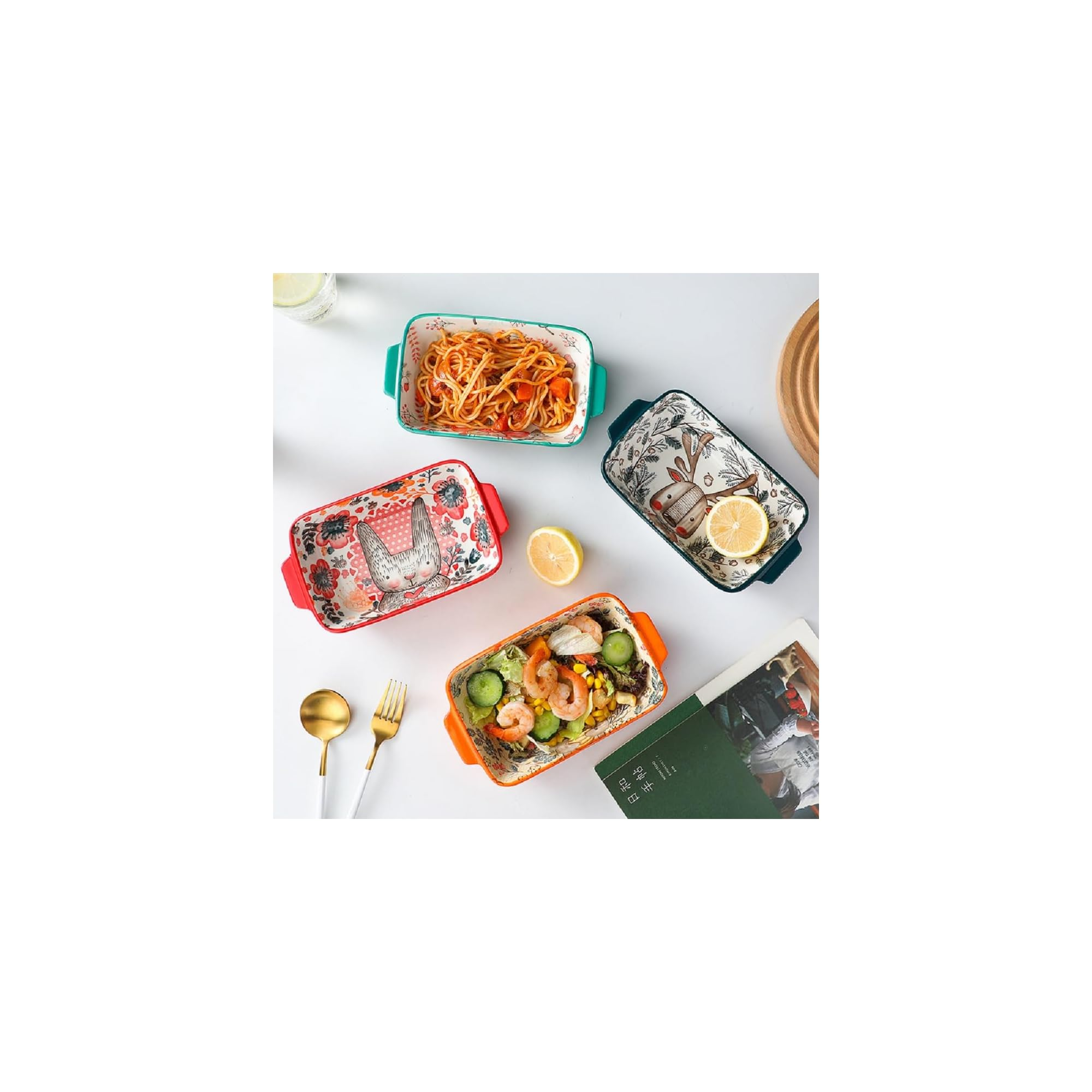 Vier bunte Keramikschalen mit Tieren und Essen, dazu ein Löffel, eine Gabel und Zitronen auf weißem Tisch.