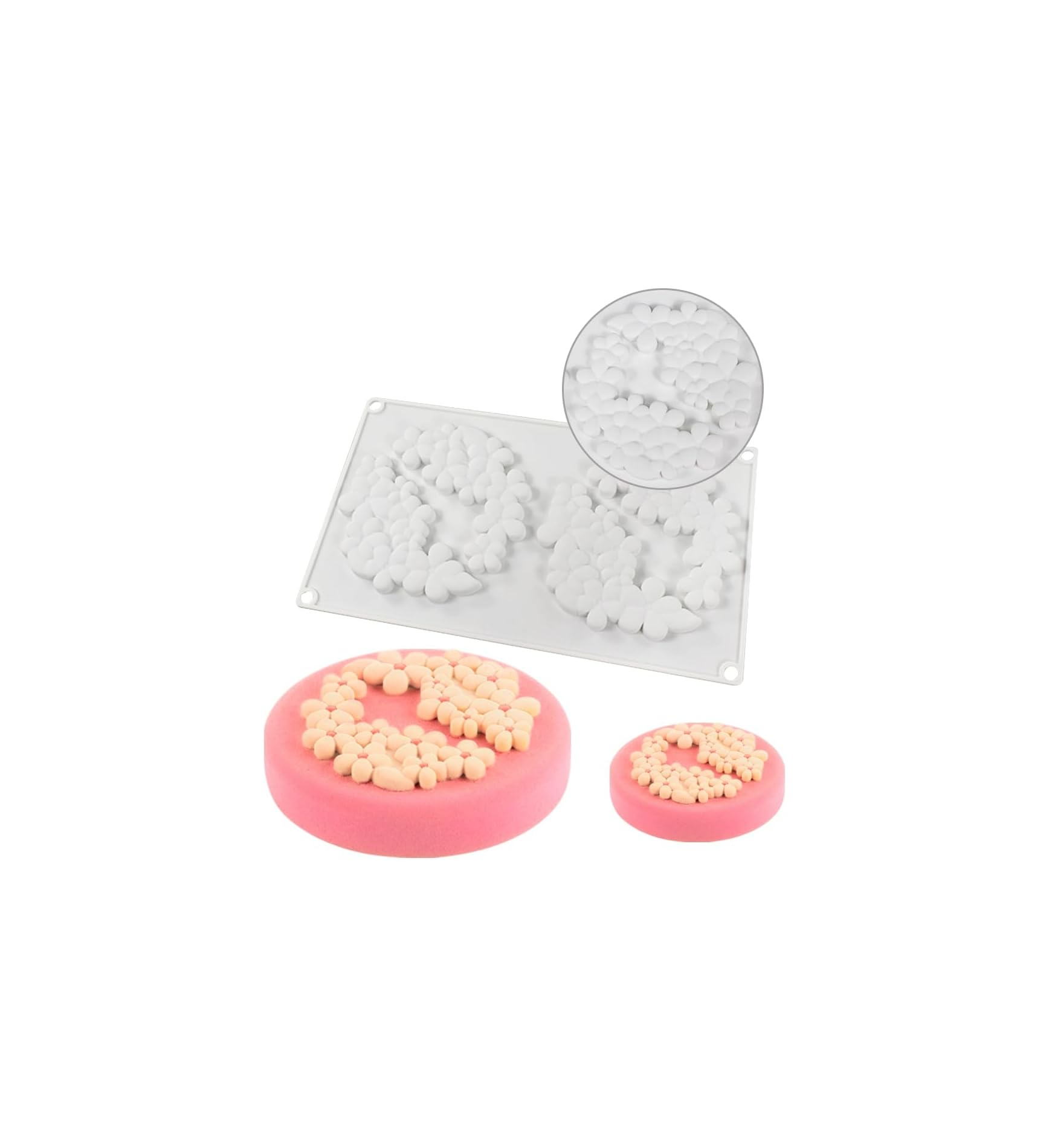 Eine weiße Silikonform mit Blumenmuster und zwei runde rosa Kuchen mit Blumenaufsatz auf weißem Hintergrund.