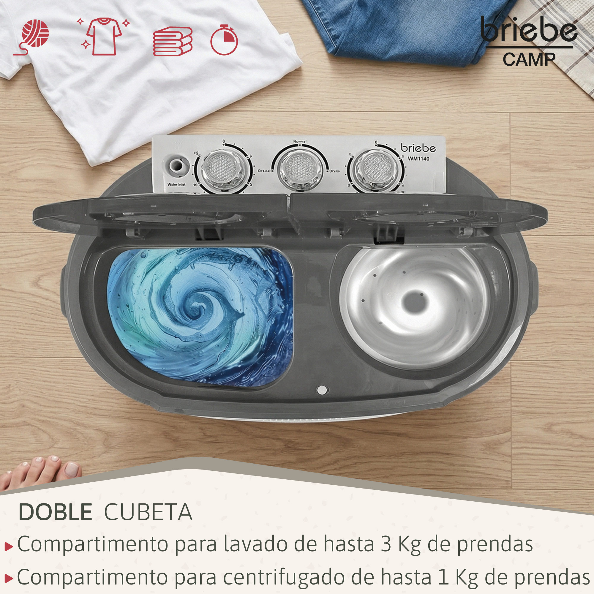 Una minilavadora de doble cubeta gris en el suelo de madera, con ropa cerca.