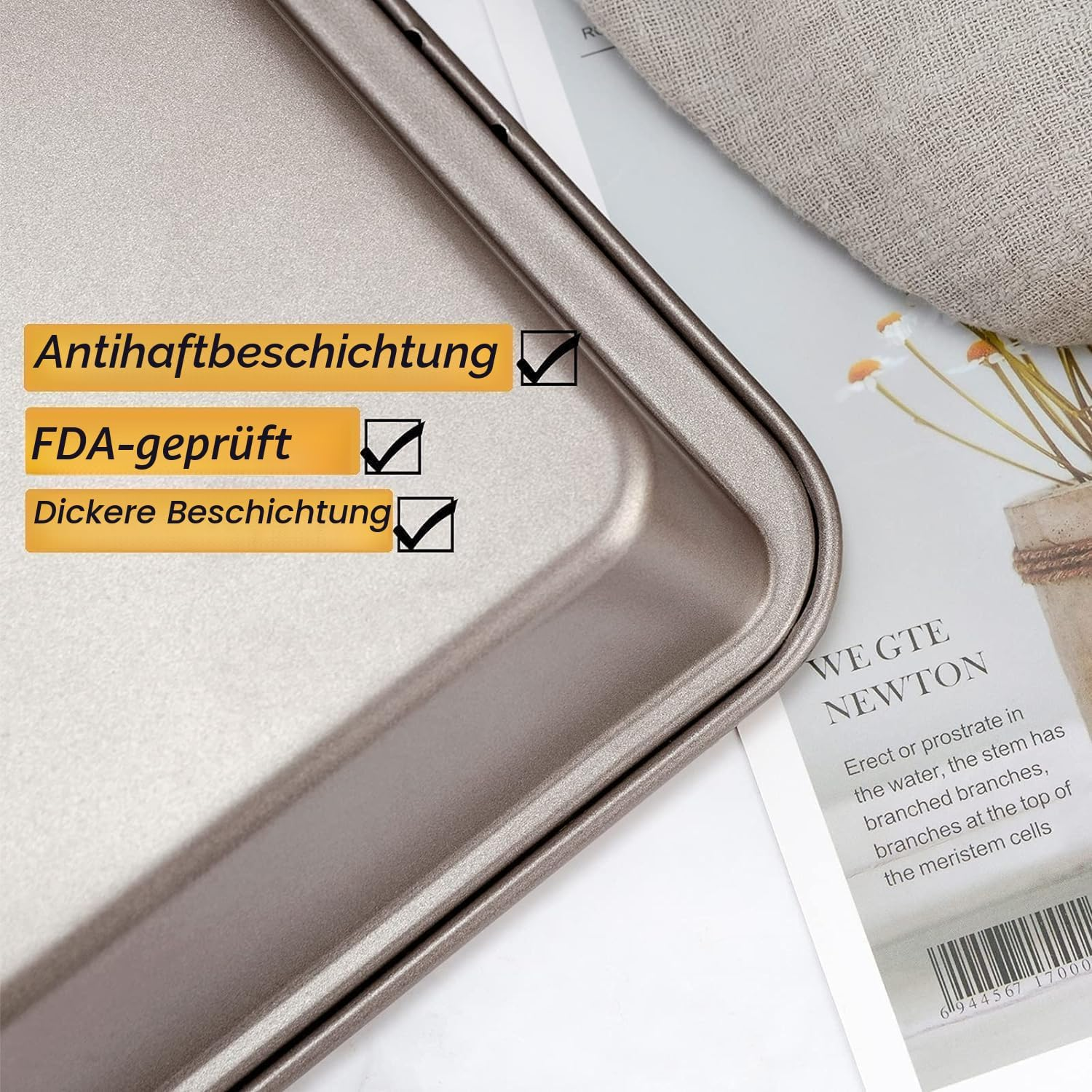 Ein metallenes Backblech auf Papier mit deutschem Text und Häkchen, neben einem Tuch und einer Pflanze.