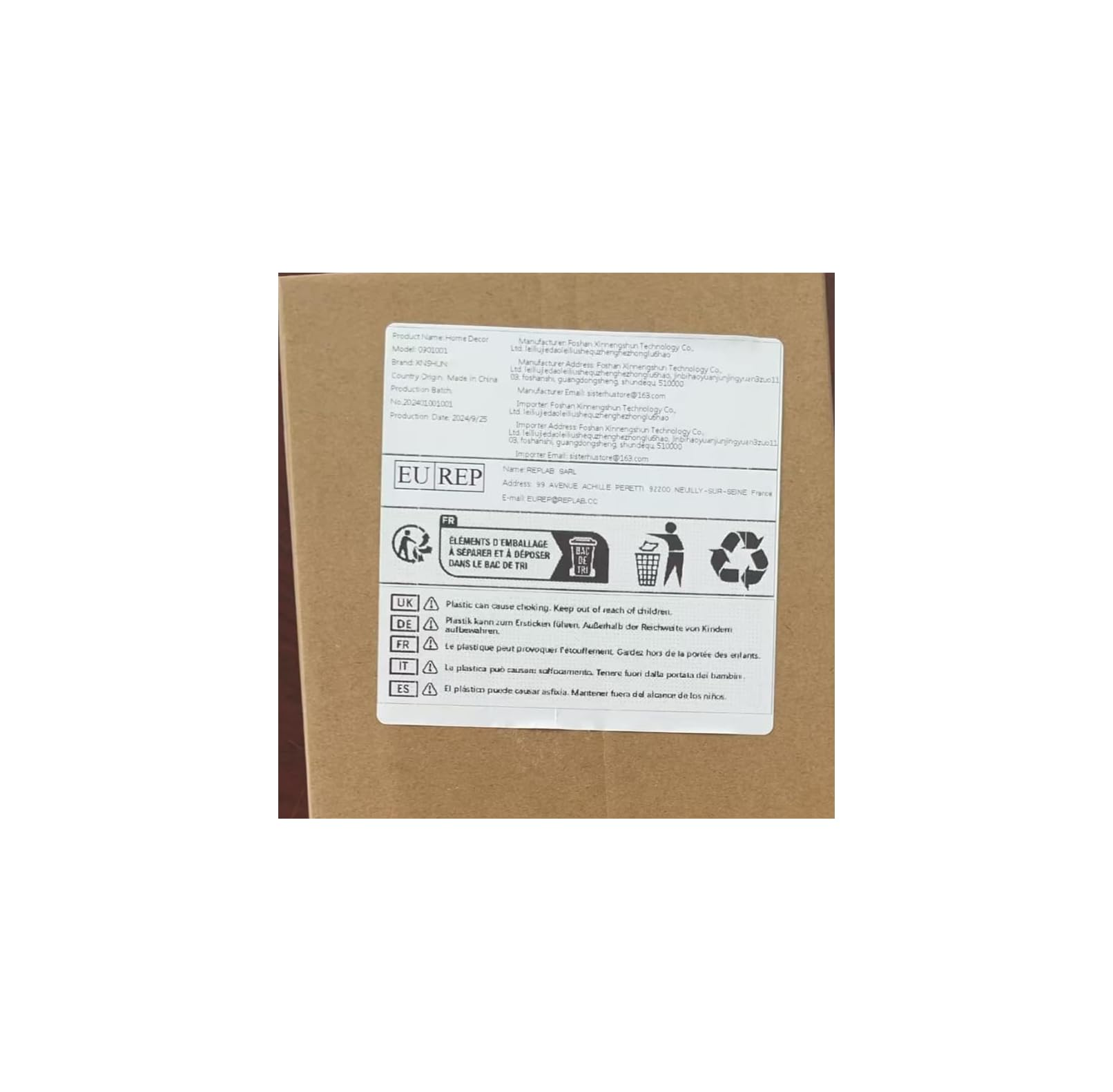 Ein weißes Produktetikett mit Text, EU REP Logo und Recycling-Symbolen auf einem braunen Pappkarton.