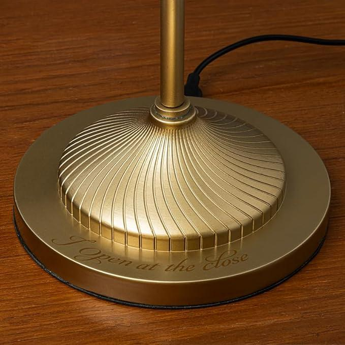 Base de lámpara dorada con diseño acanalado e inscripción en superficie de madera.