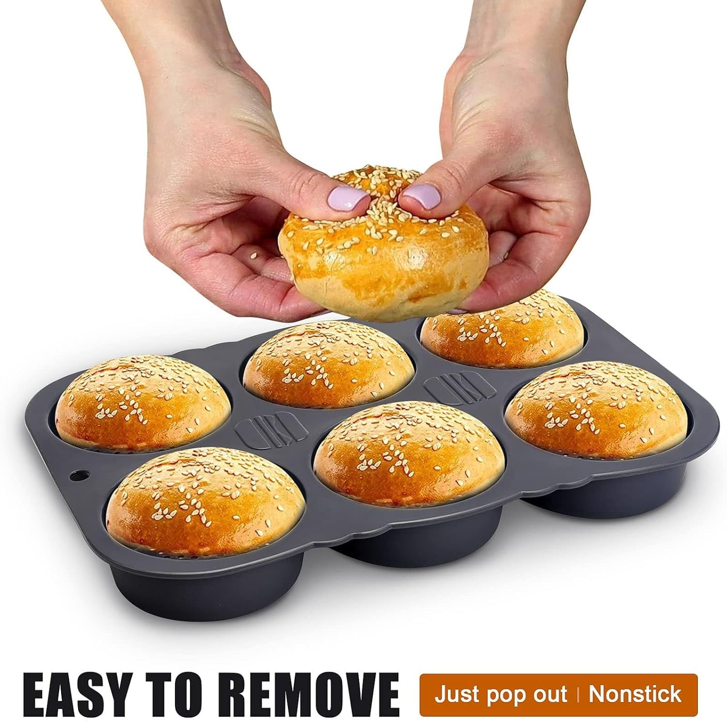 Hände halten ein gebackenes Sesambrötchen über eine graue Muffinform.