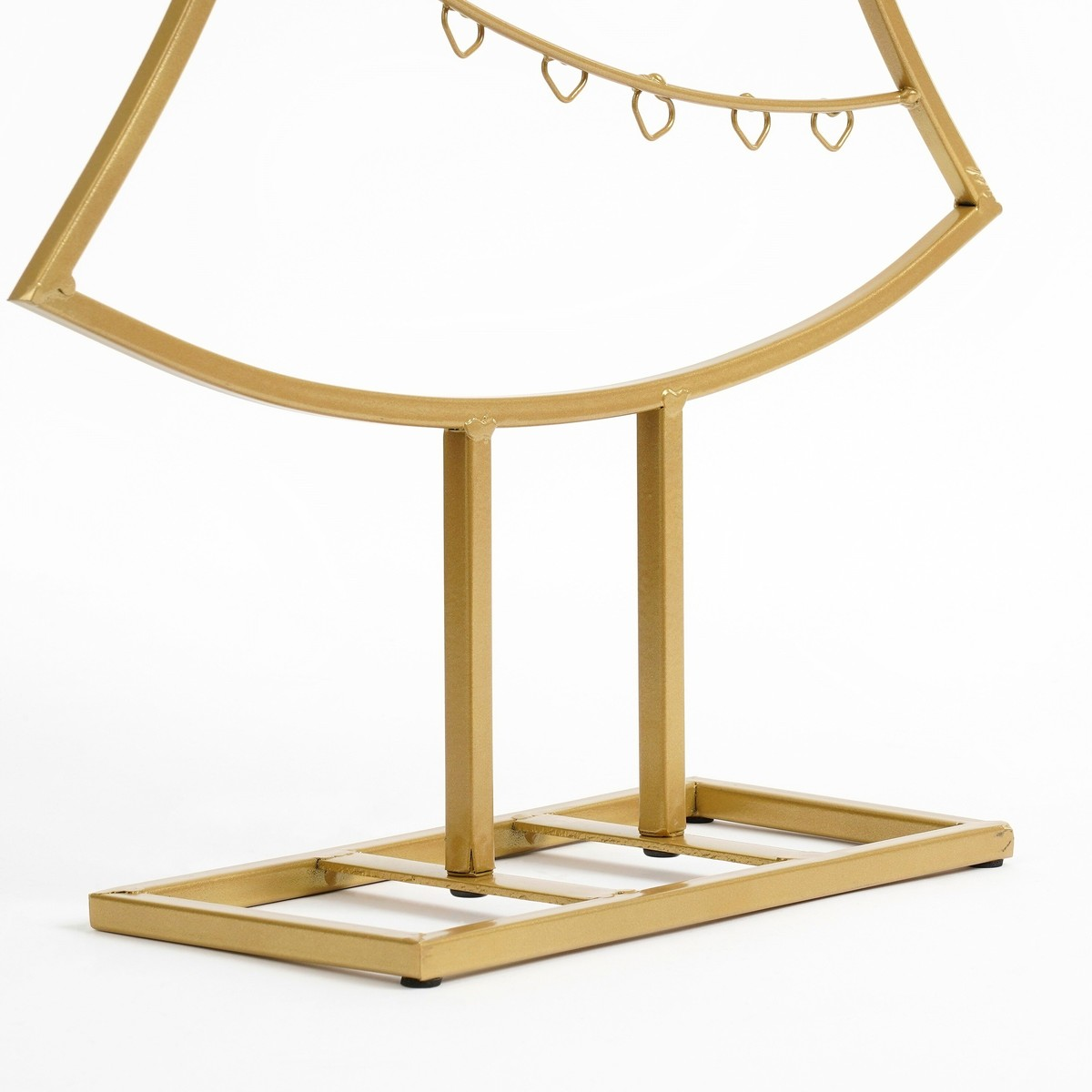 Een gouden metalen standaard met een gebogen frame en kleine hangende ringen op een witte achtergrond.