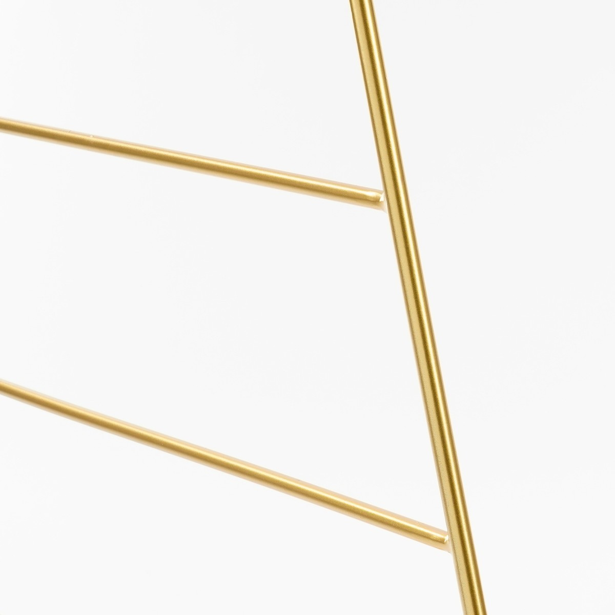 Gouden metalen staven vormen een geometrische structuur tegen een witte achtergrond.