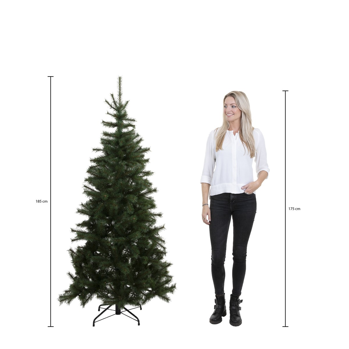 Een blonde vrouw in wit shirt en zwarte broek staat naast een kunstkerstboom van 185 cm met hoogtemarkering.