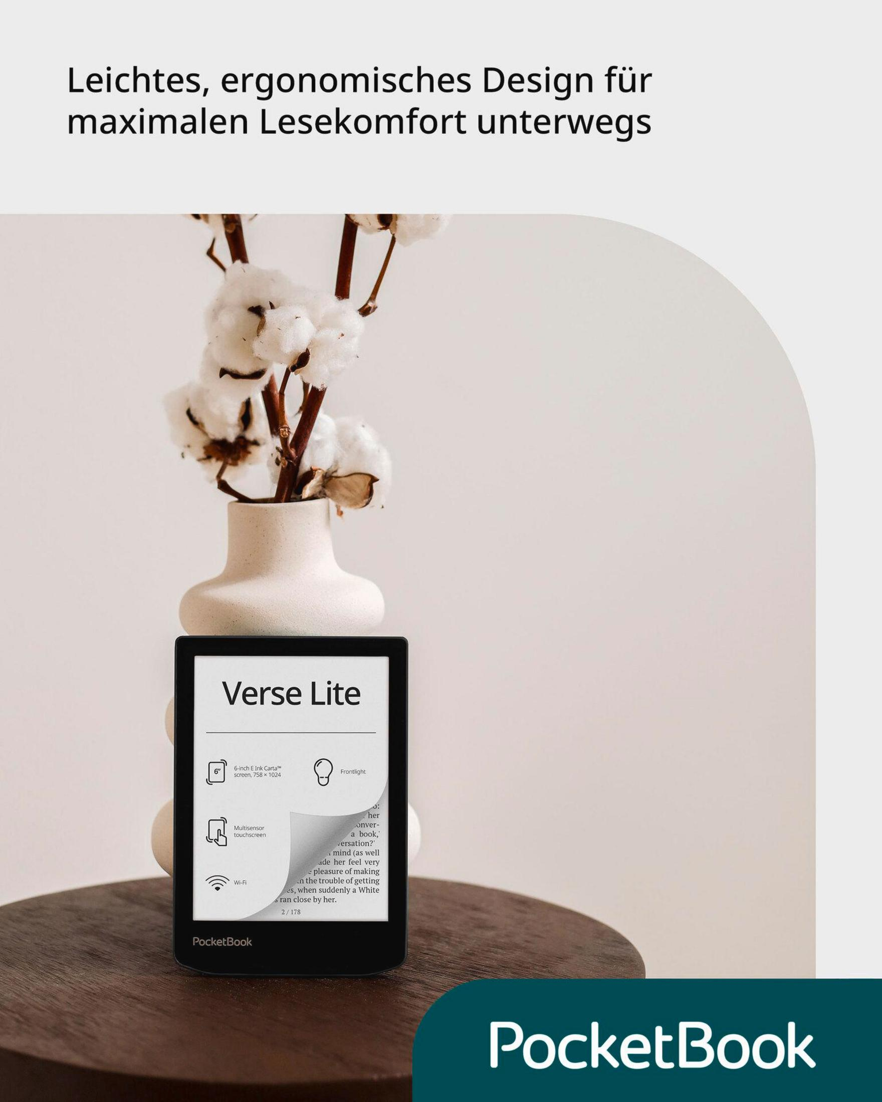 Ein schwarzer PocketBook Verse Lite E-Reader steht auf einem Holztisch vor einer Vase mit Baumwollzweigen.