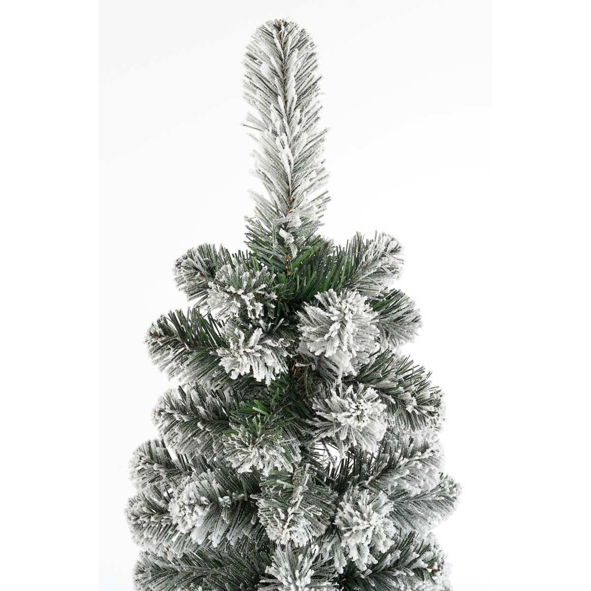Een close-up van de besneeuwde top van een kunstkerstboom met groene naalden tegen een witte achtergrond.