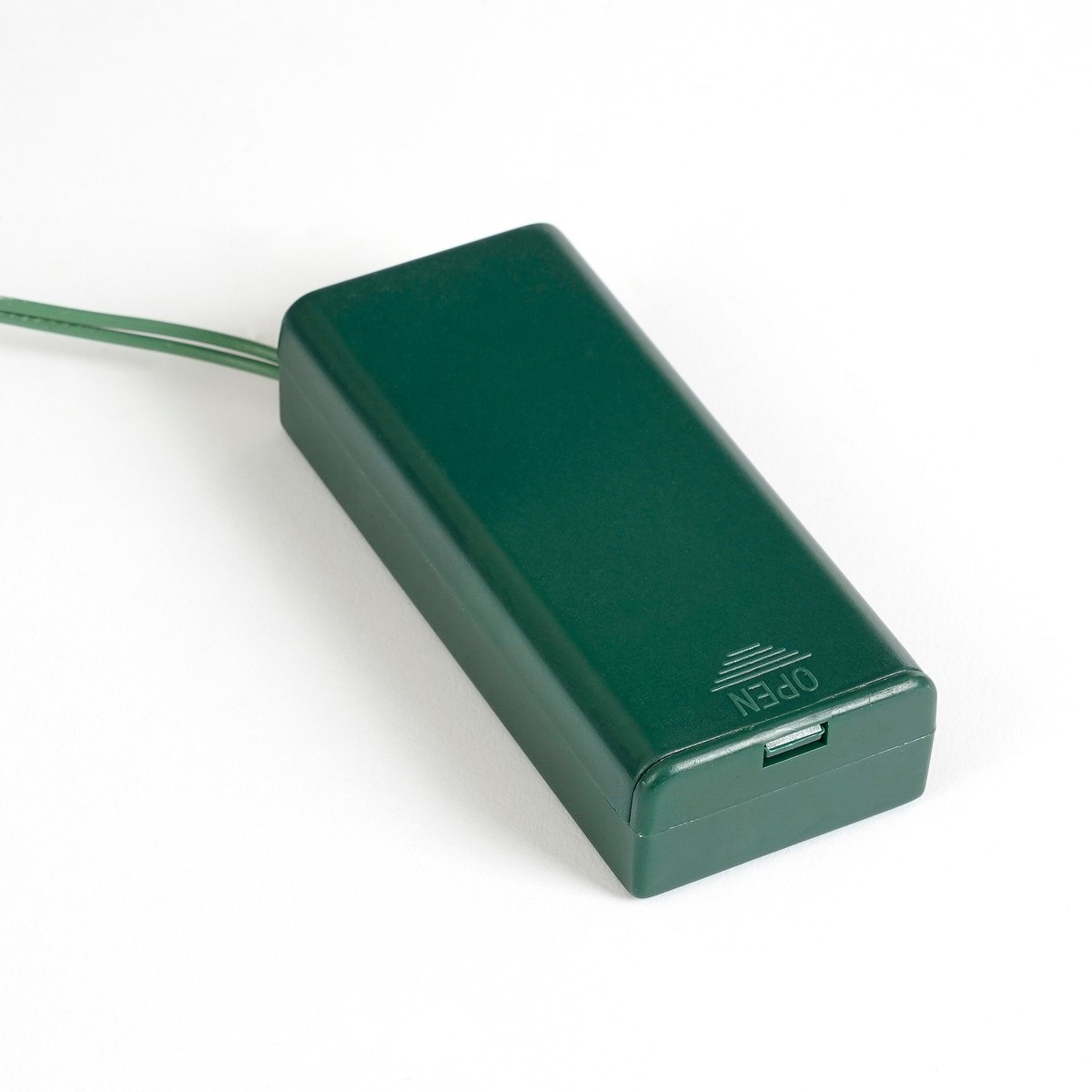 Een groene batterijdoos met aangesloten groene draden op een witte achtergrond.