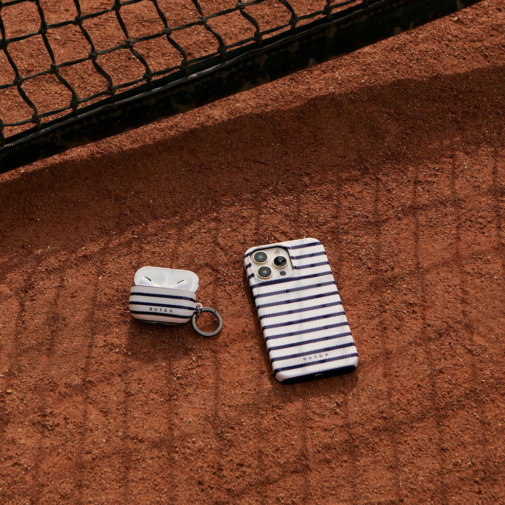 Blauw-wit gestreept hoesje en oordopjesdoosje op rood gravel naast een net.