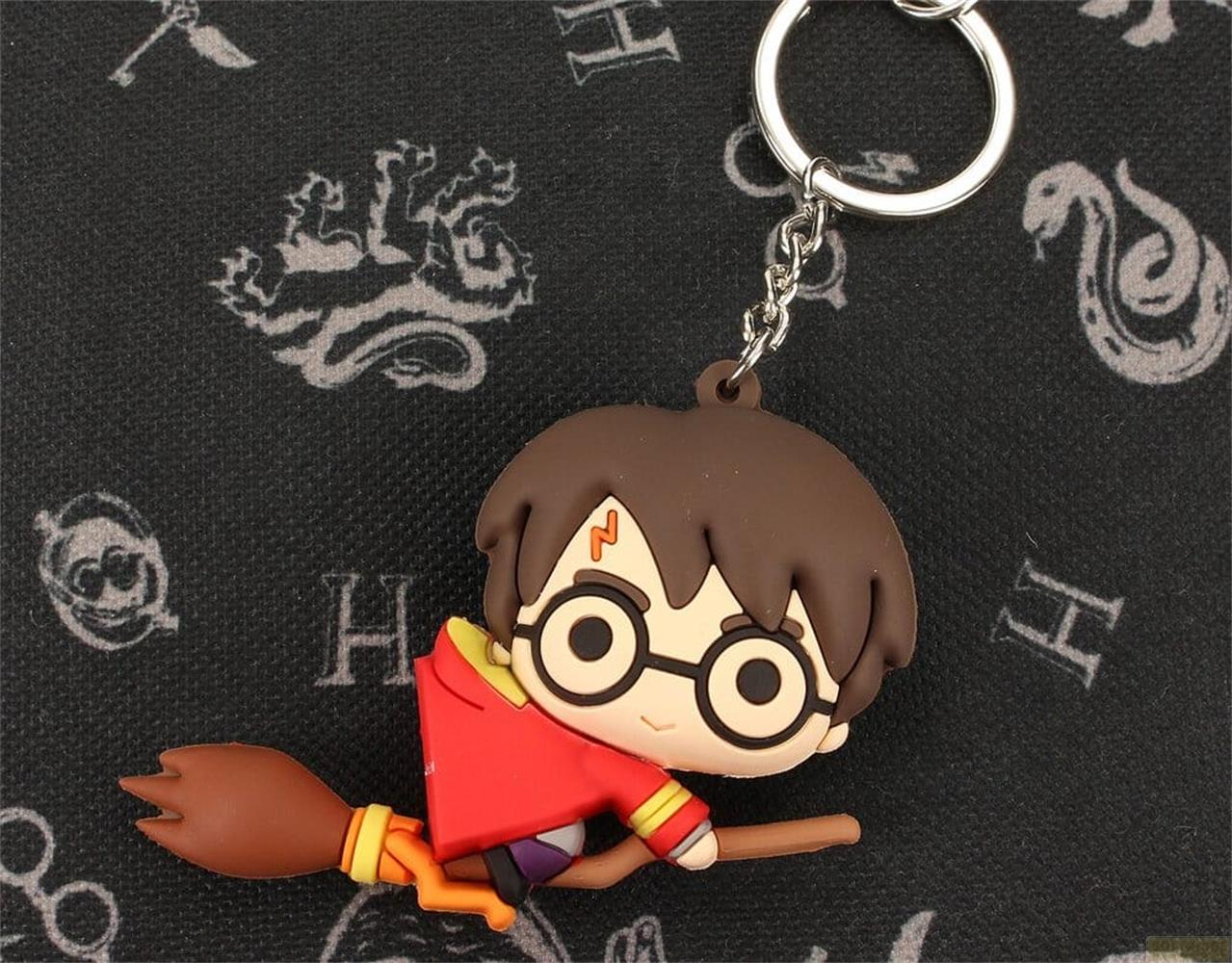 Llavero de Harry Potter con un personaje en escoba sobre fondo negro con símbolos.