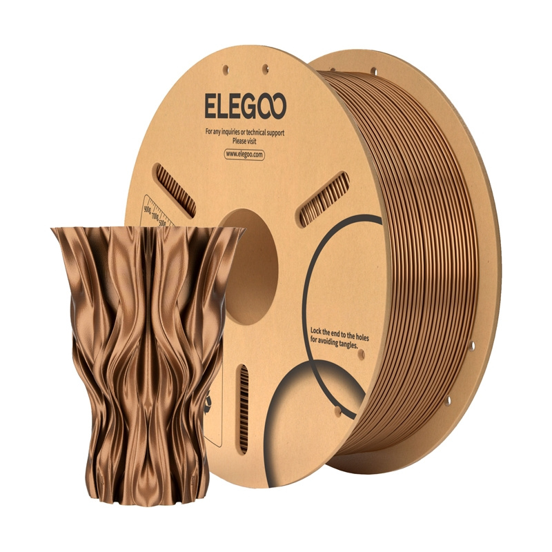 Una bobina di filamento per stampante 3D in bronzo accanto a un vaso ondulato.