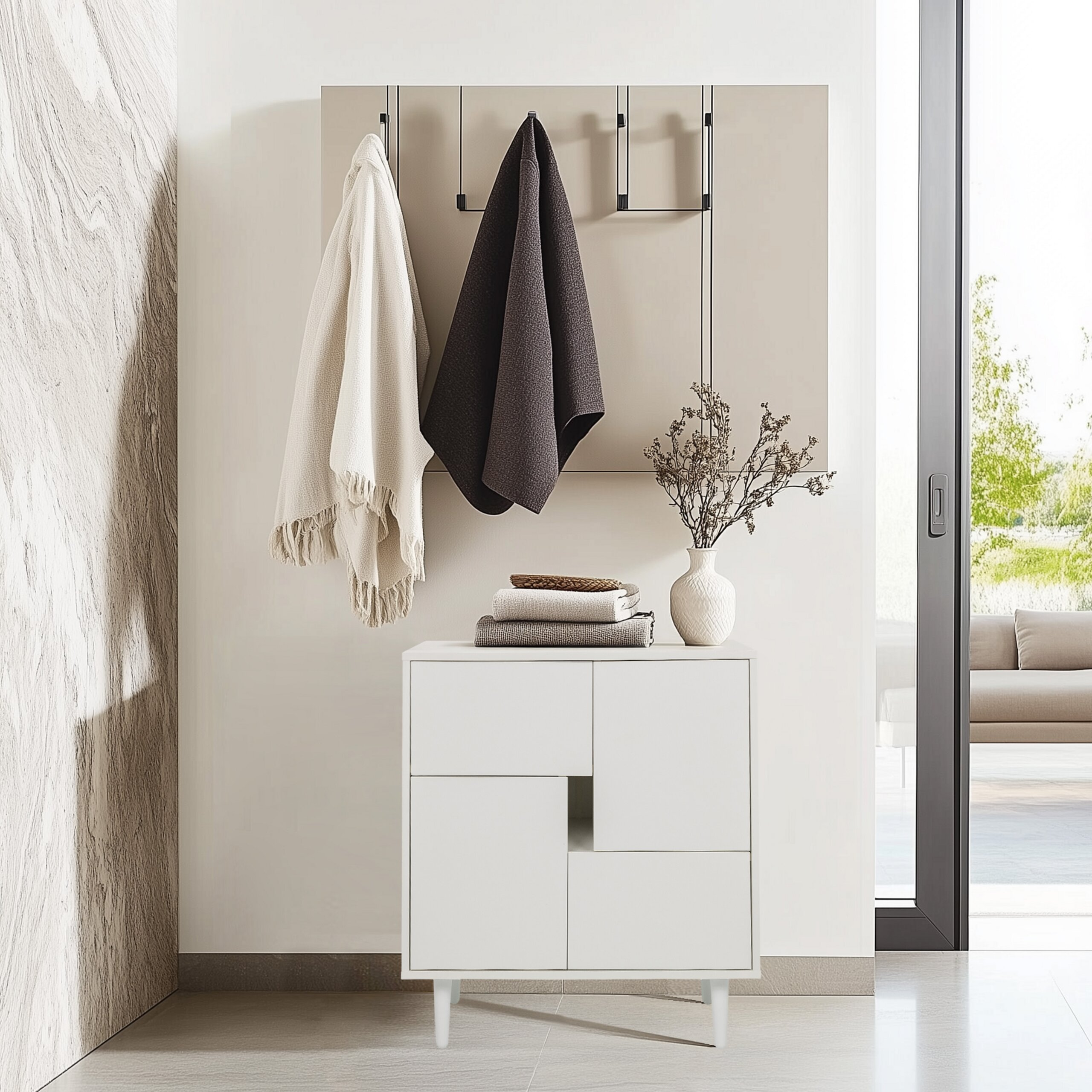 Ein weißer Schrank mit Handtüchern, einer Vase und einer Garderobe an einer neutralen Wand.