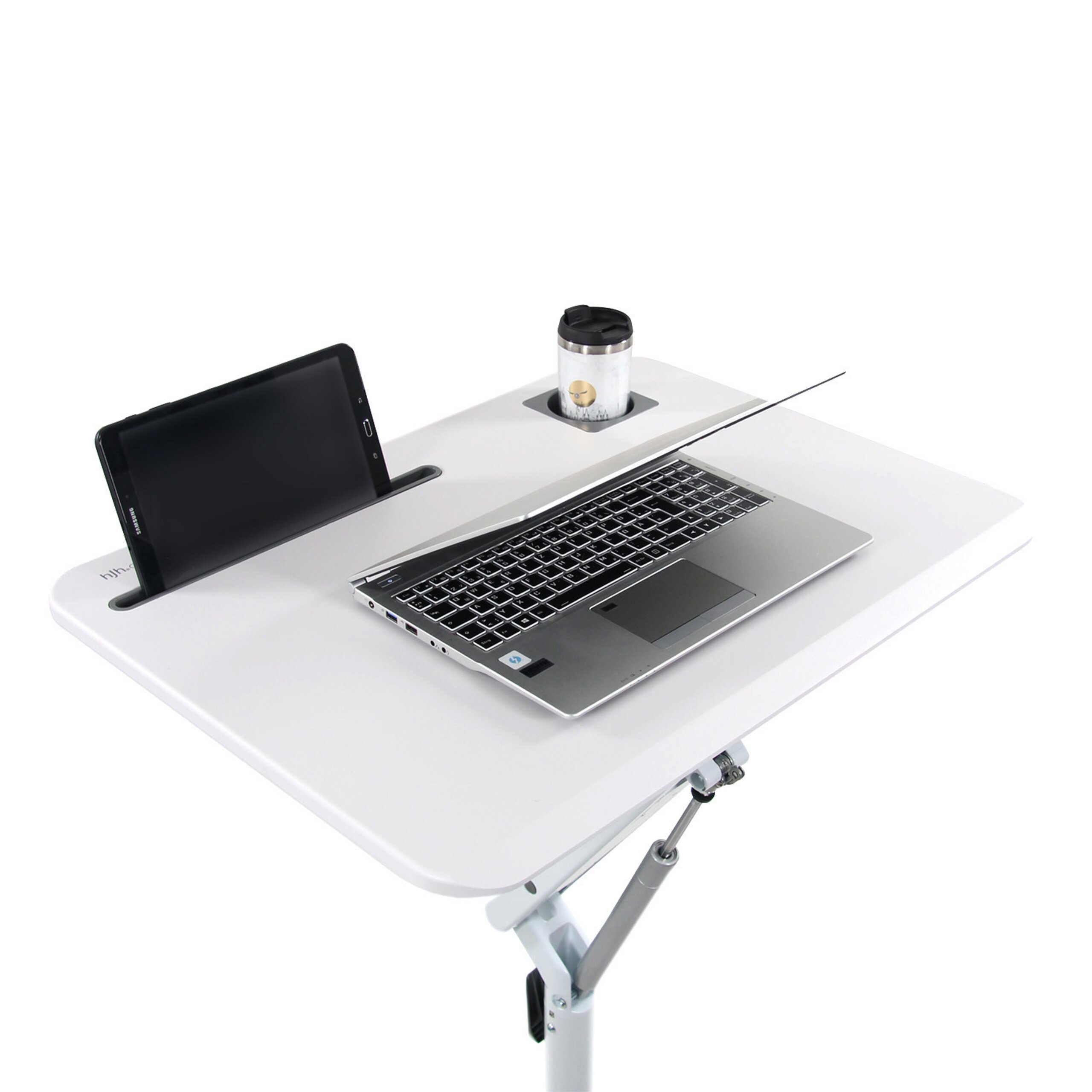 Ein weißer, höhenverstellbarer Tisch mit Laptop, Tablet im Schlitz und Becherhalter gegen weißen Hintergrund.