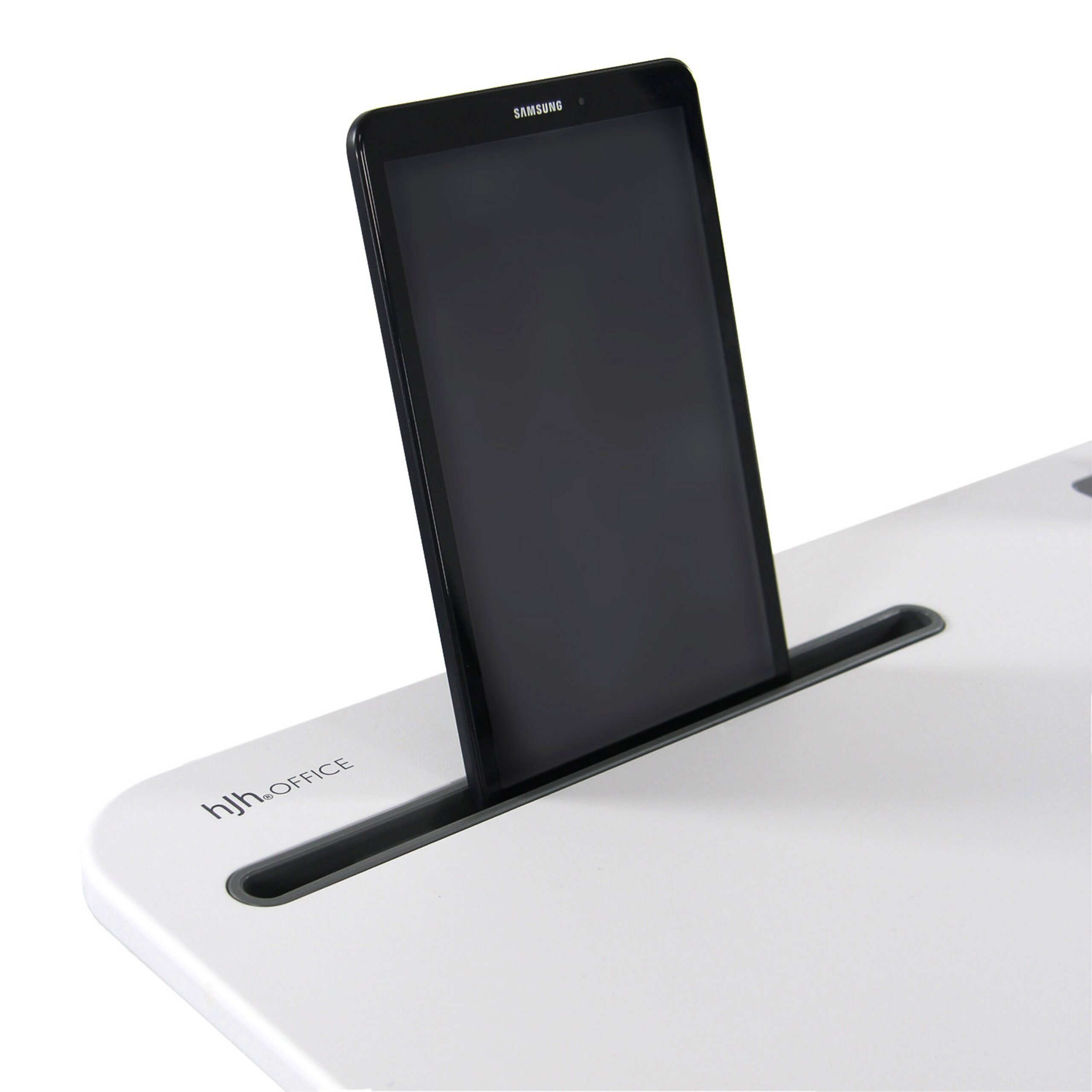 Ein schwarzes Samsung-Tablet steht aufrecht in einem Schlitz an einem weißen Schreibtisch vor weißem Hintergrund.