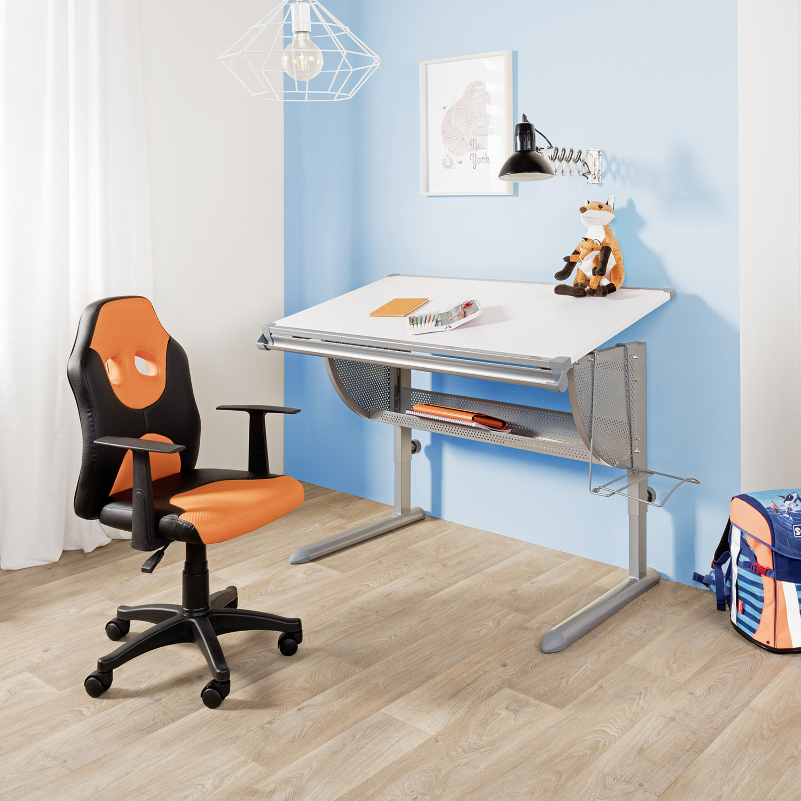 Kinderzimmer mit einem weißen Schreibtisch, einem schwarz-orangen Stuhl und einer Schultasche auf dem Boden.