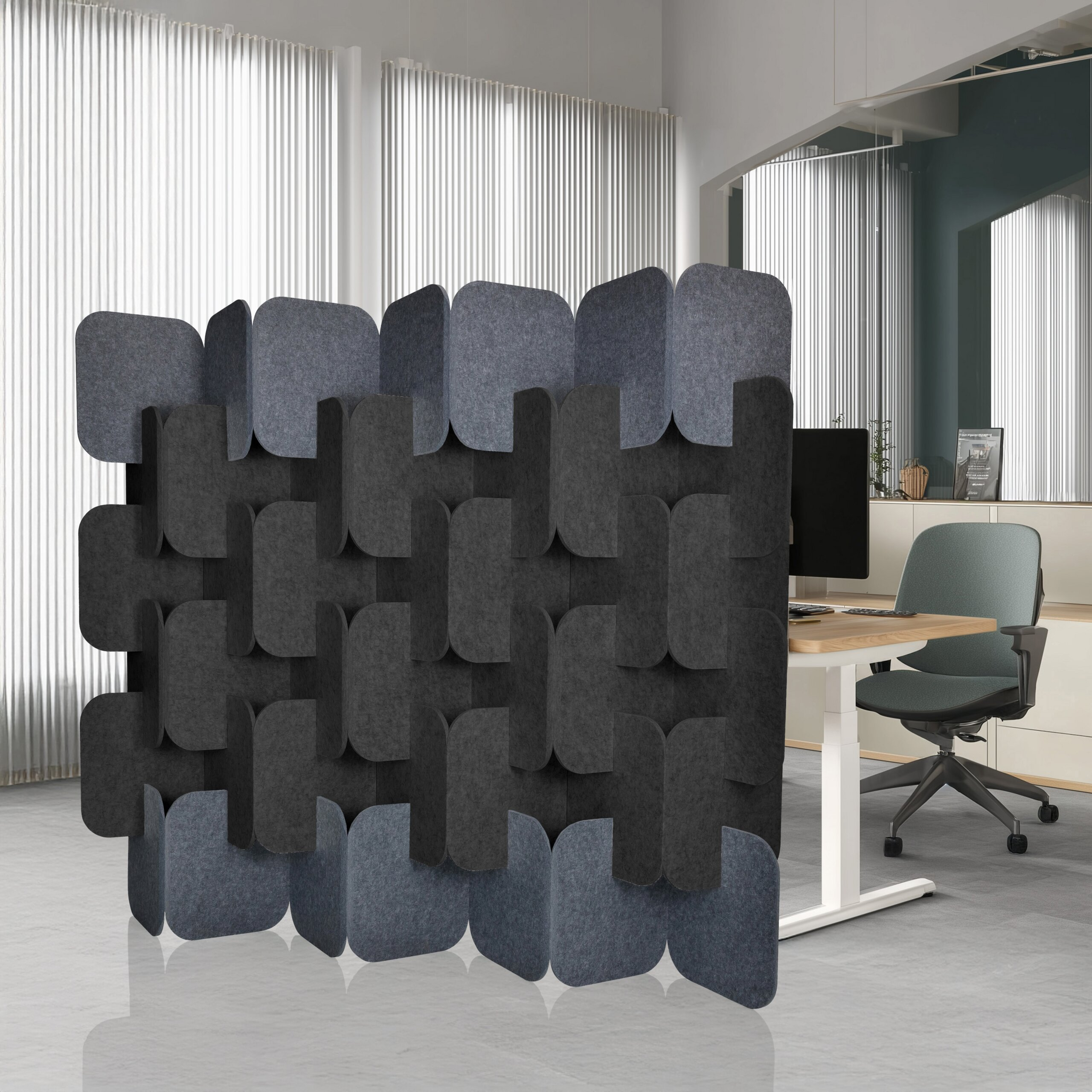 Moderne Raumteiler aus Filzplatten in Grau und Anthrazit stehen im Büro vor einem Schreibtisch.