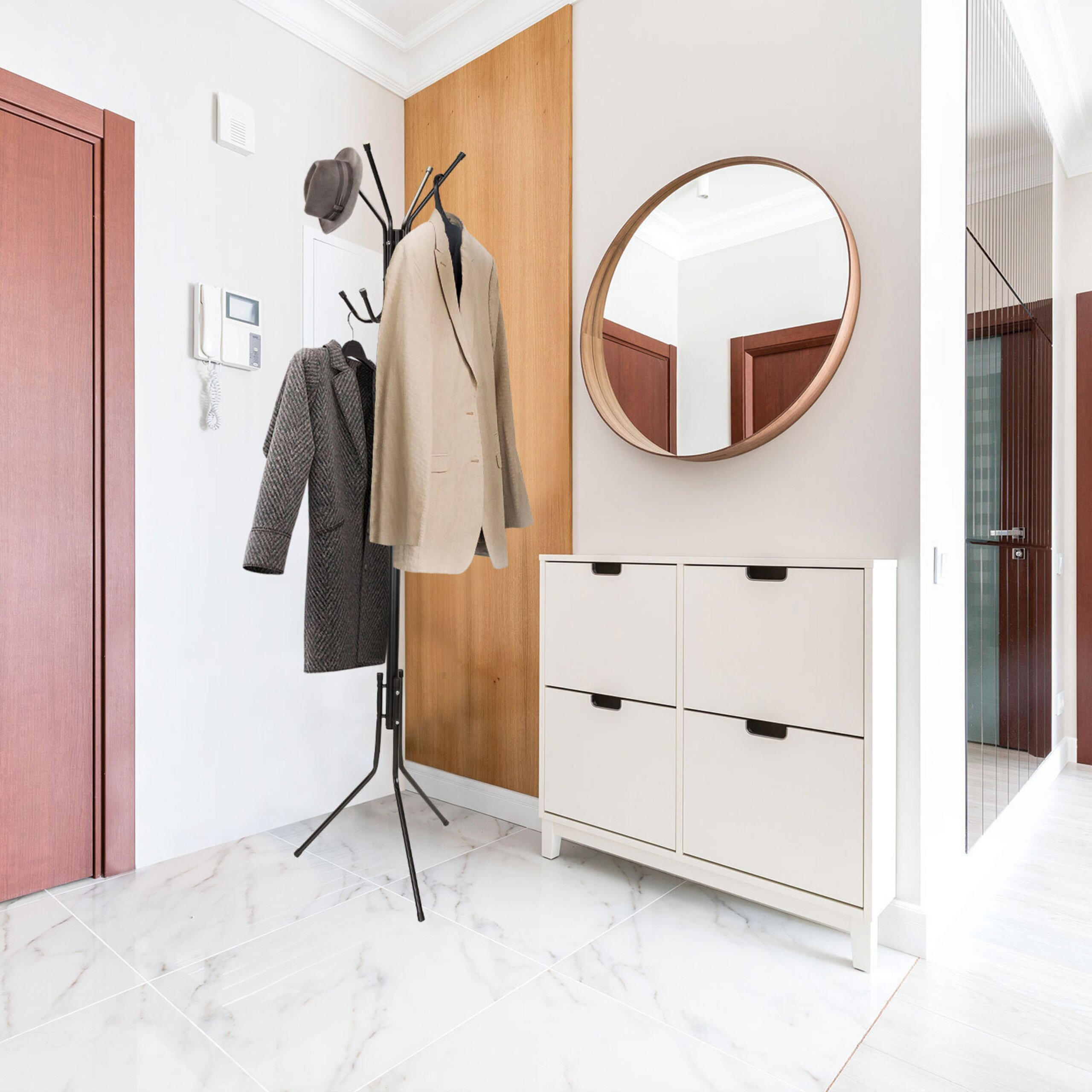 Ein heller Flur mit weißem Schuhschrank, rundem Spiegel, Garderobe mit Jacken und Marmorboden.