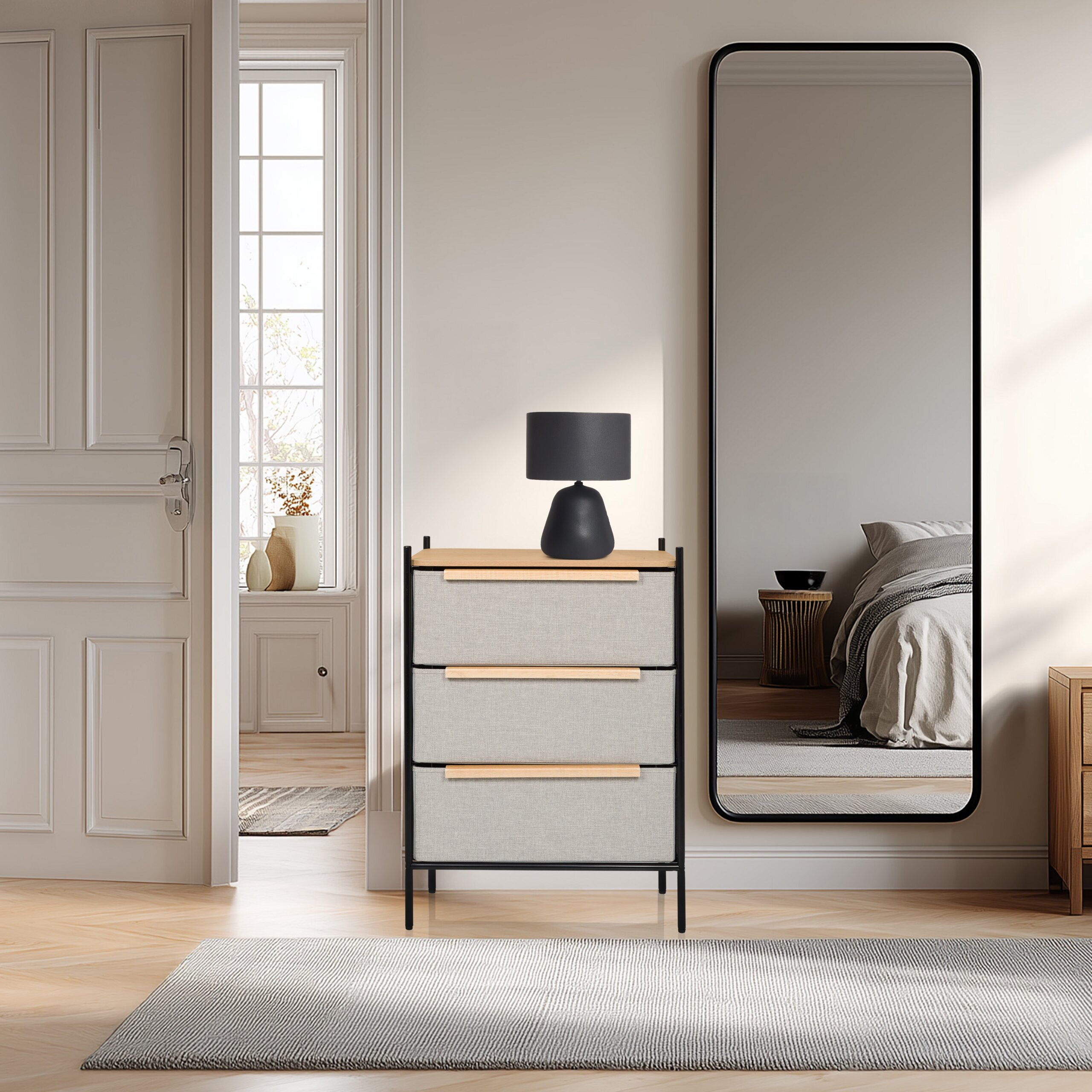 Flur mit grauer Kommode, schwarzer Lampe, langem Spiegel und offener Tür.
