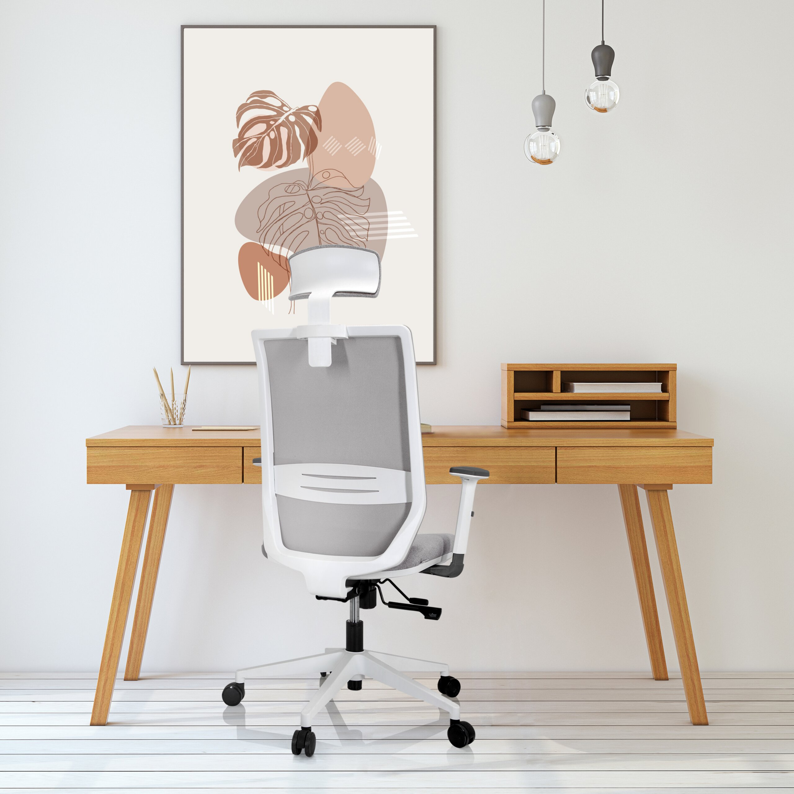 Ein weißer Buerostuhl steht vor einem Holztisch mit einer Lampe und einem grossen Bild an der Wand.