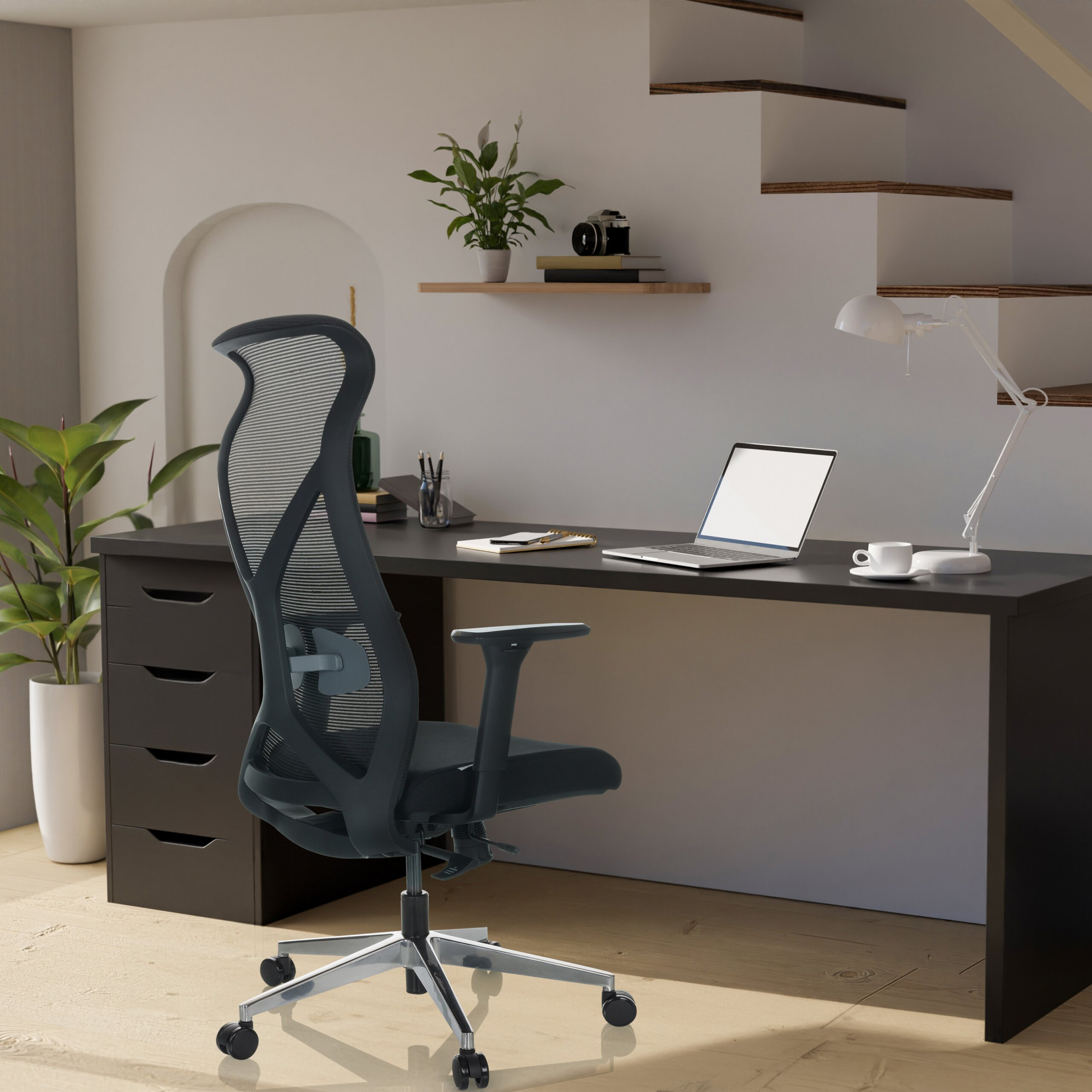 Ein modernes Homeoffice mit dunklem Schreibtisch, ergonomischem Netzstuhl, Laptop, Lampe und Regal mit Topfpflanze.