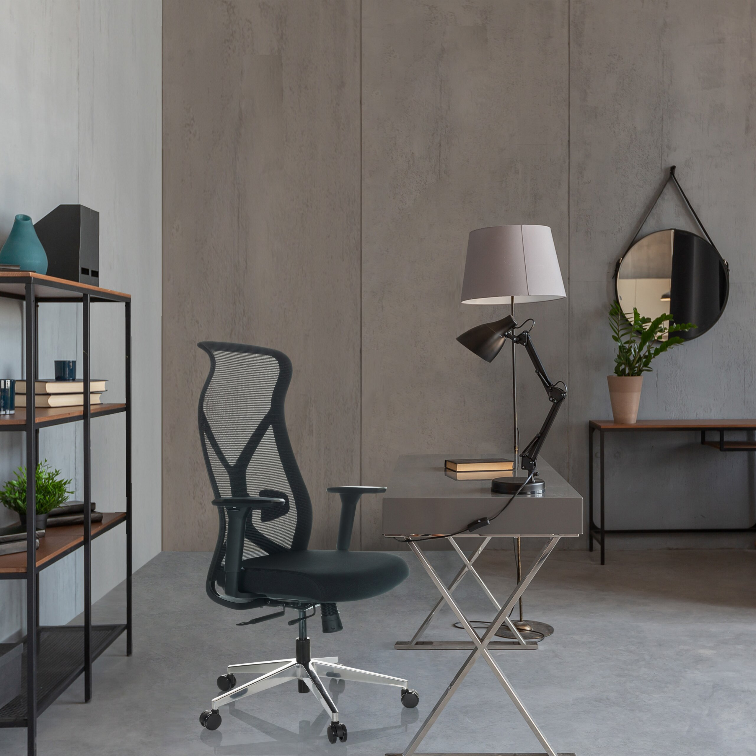 Moderne Büroinrichtung mit einem schwarzen Bürostuhl, einem Schreibtisch mit Lampe und grauen Betonwänden.